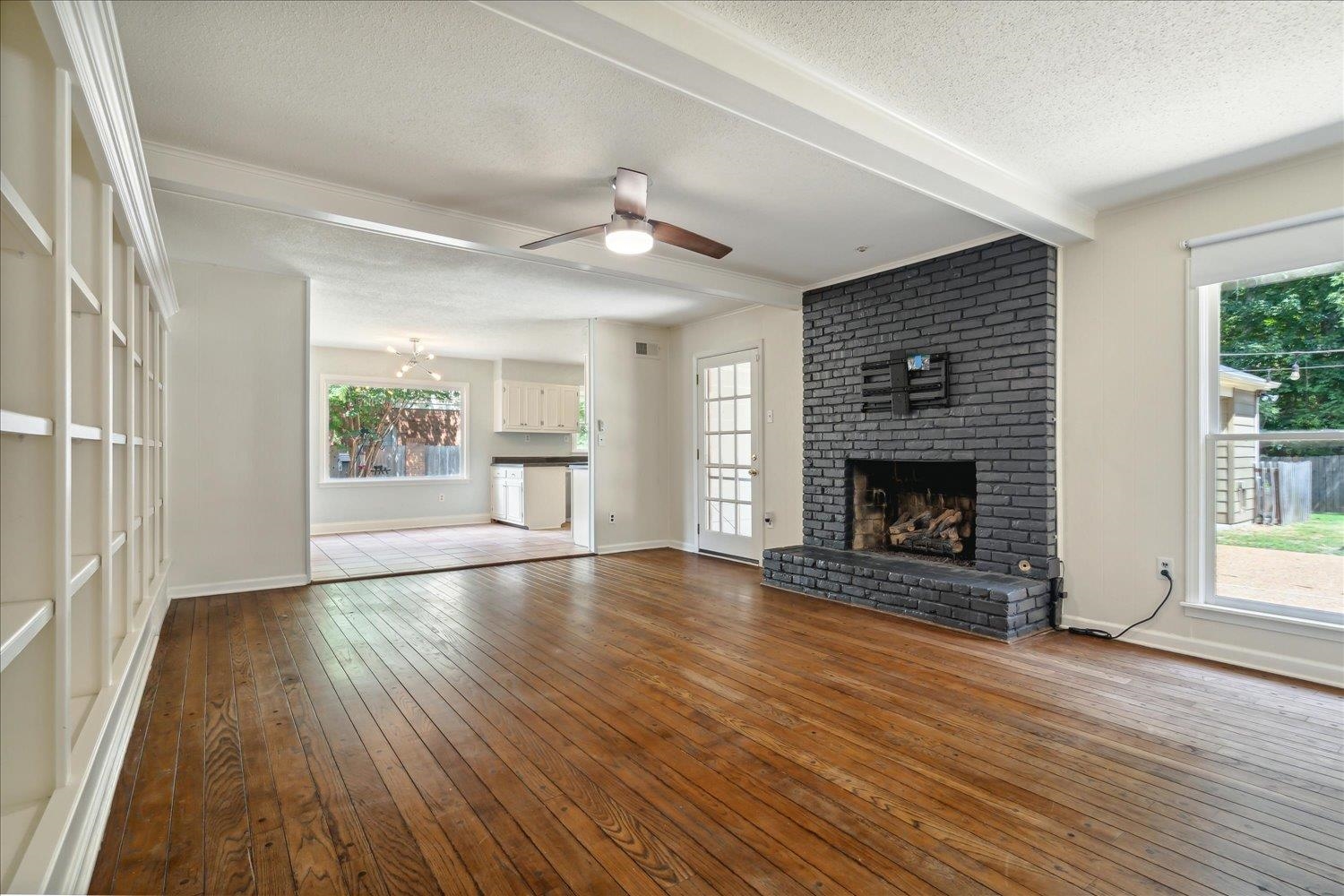 Den with Open floorplan to Kitchen.  Features wall to wall custom Built-ins,  Gas fireplace, original pegged hardwood floors.