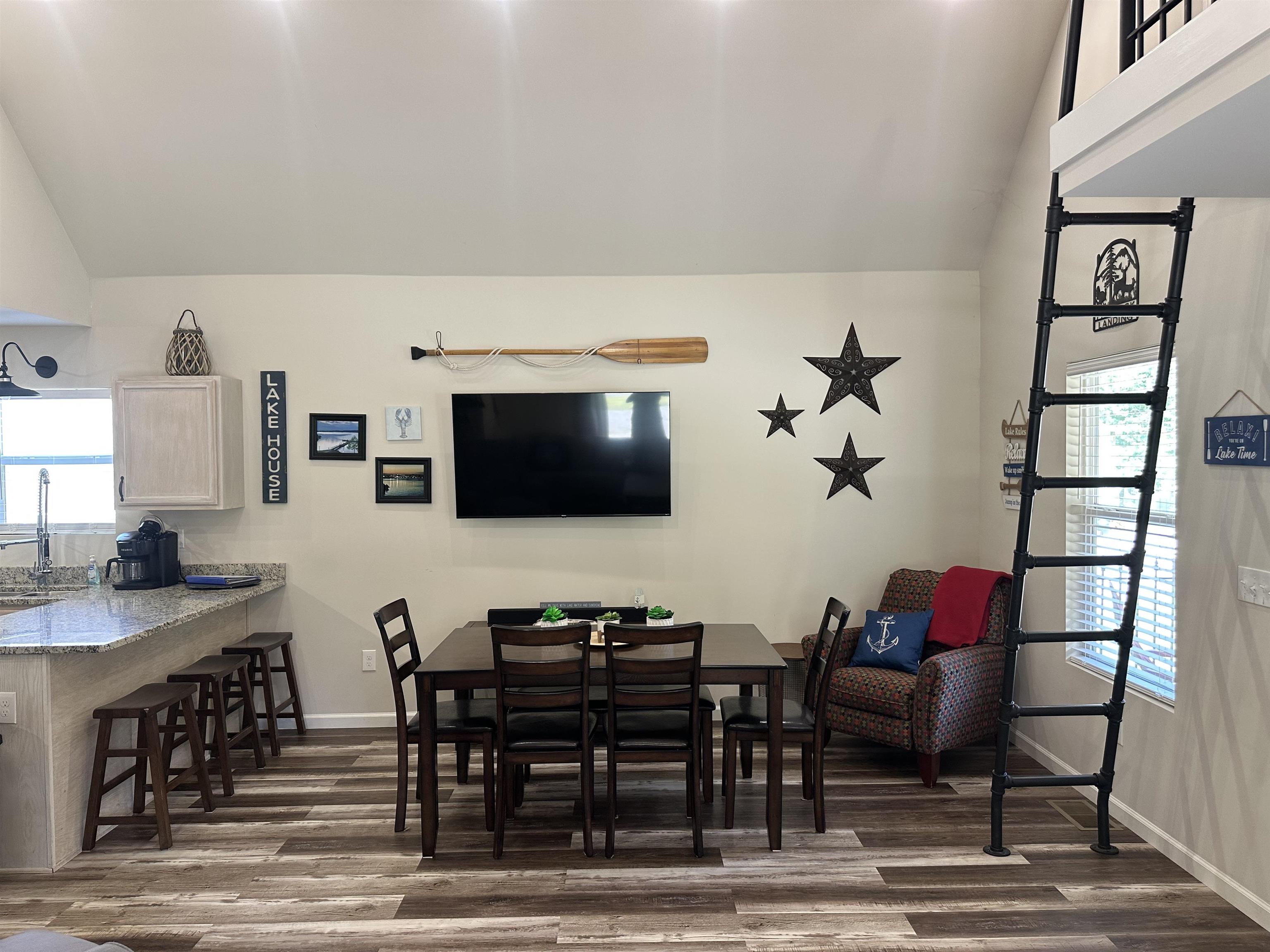 Dining room featuring dark wood-type flooring, lofted ceiling, and sink