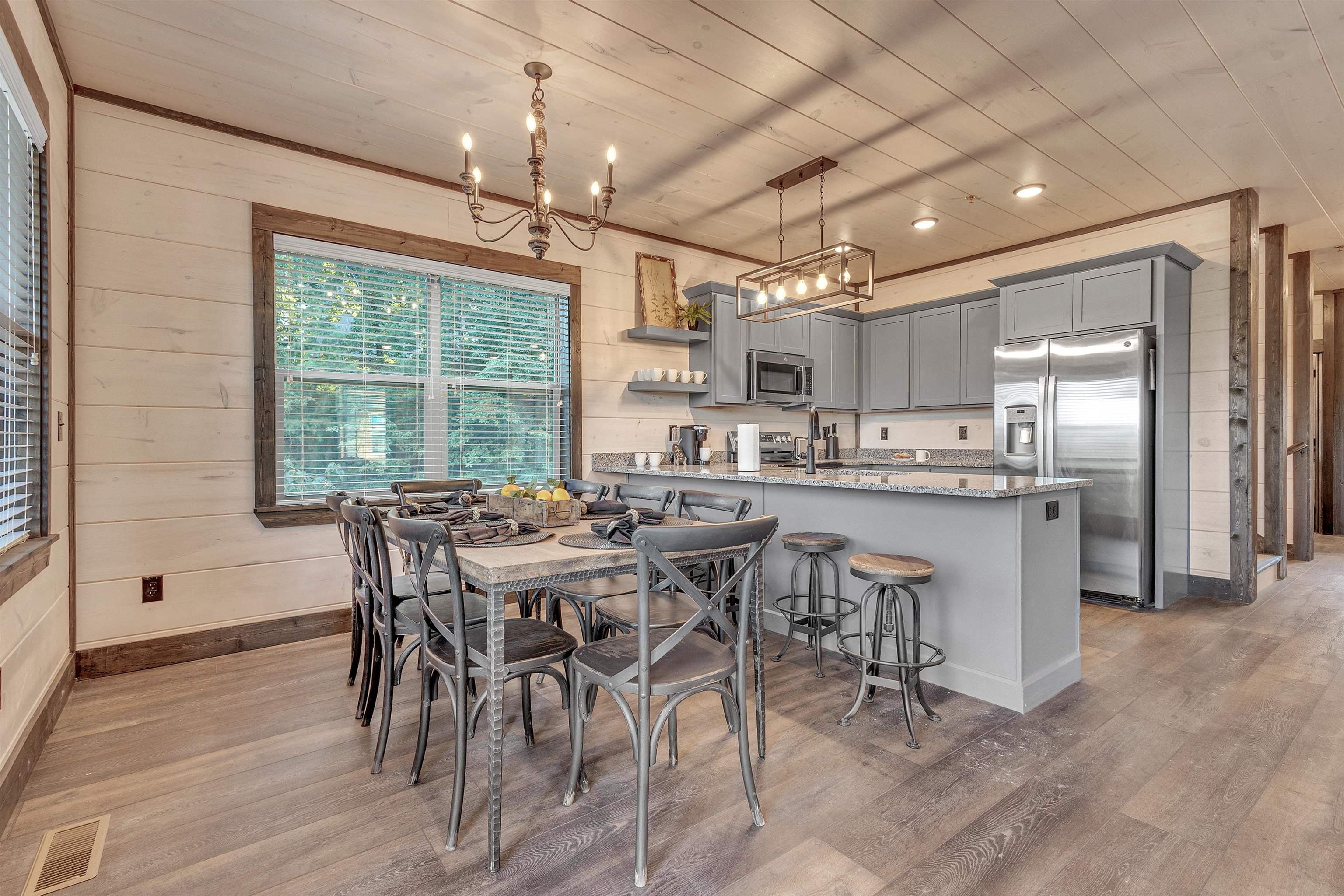 Dining room with wood ceiling, wood walls, a notable chandelier, and light hardwood / wood-style floors