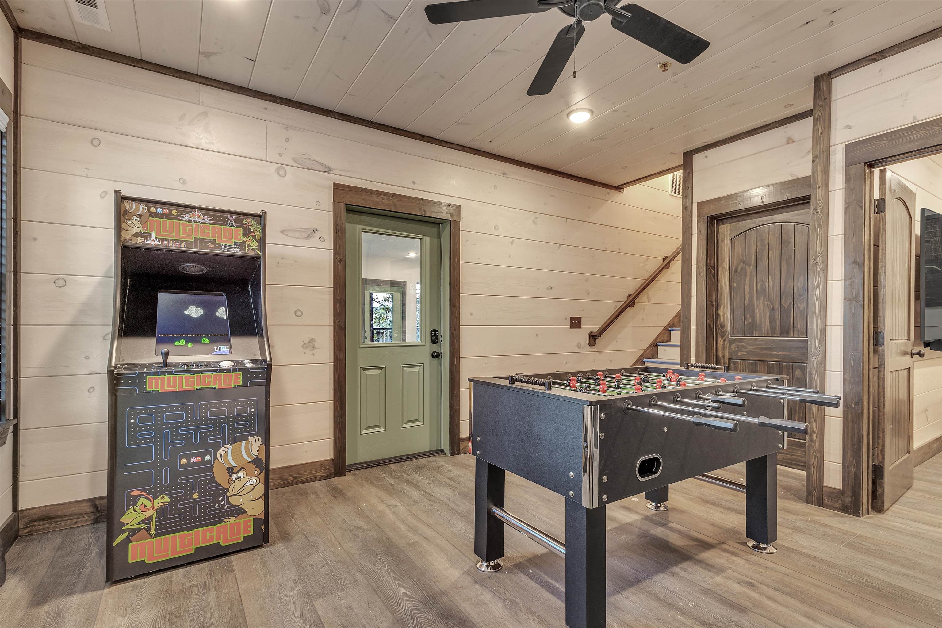 Playroom with wooden ceiling, hardwood / wood-style floors, wood walls, and ceiling fan