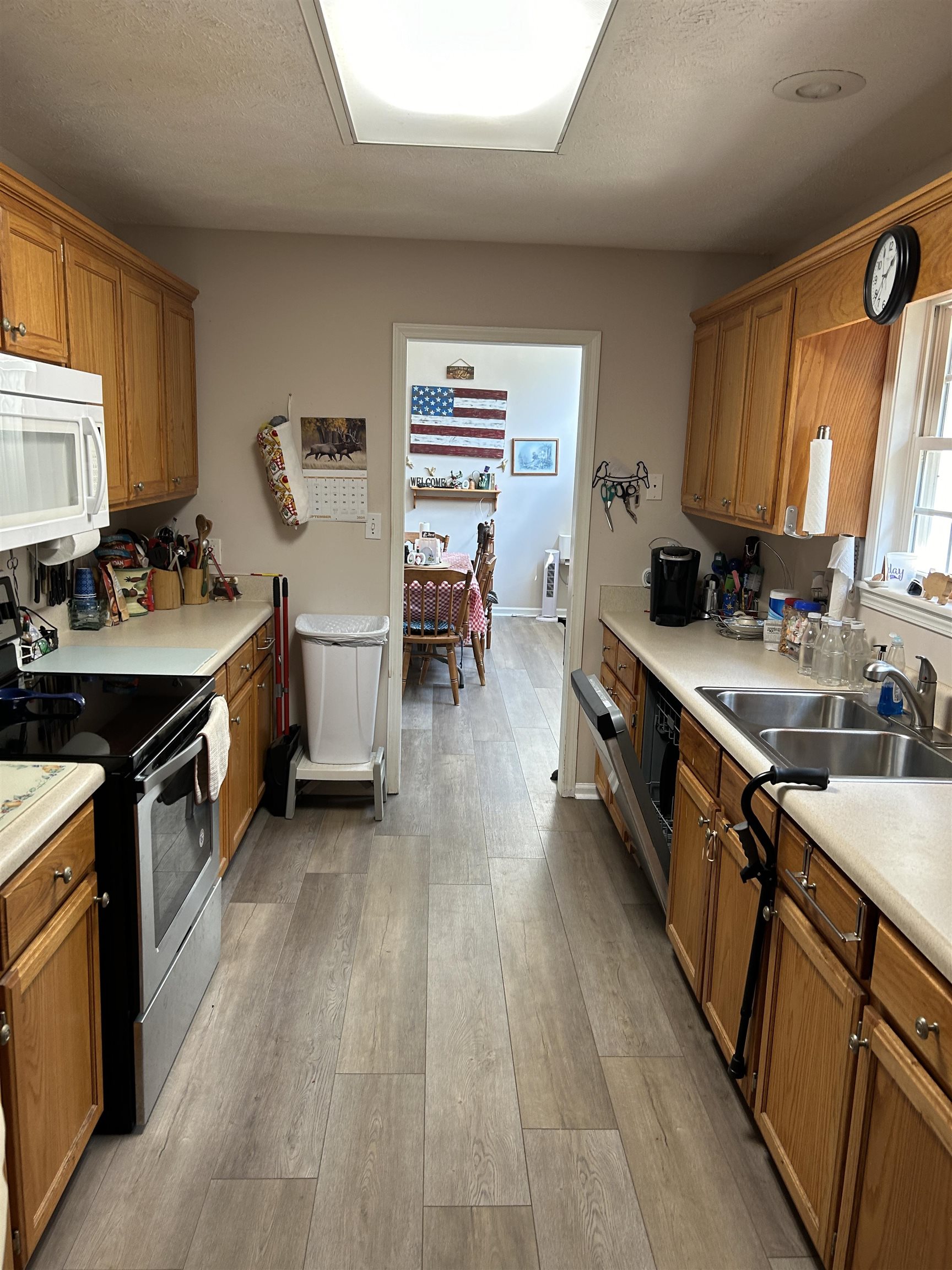 Kitchen featuring stainless steel electric stove, light hardwood / wood-style flooring, and sink