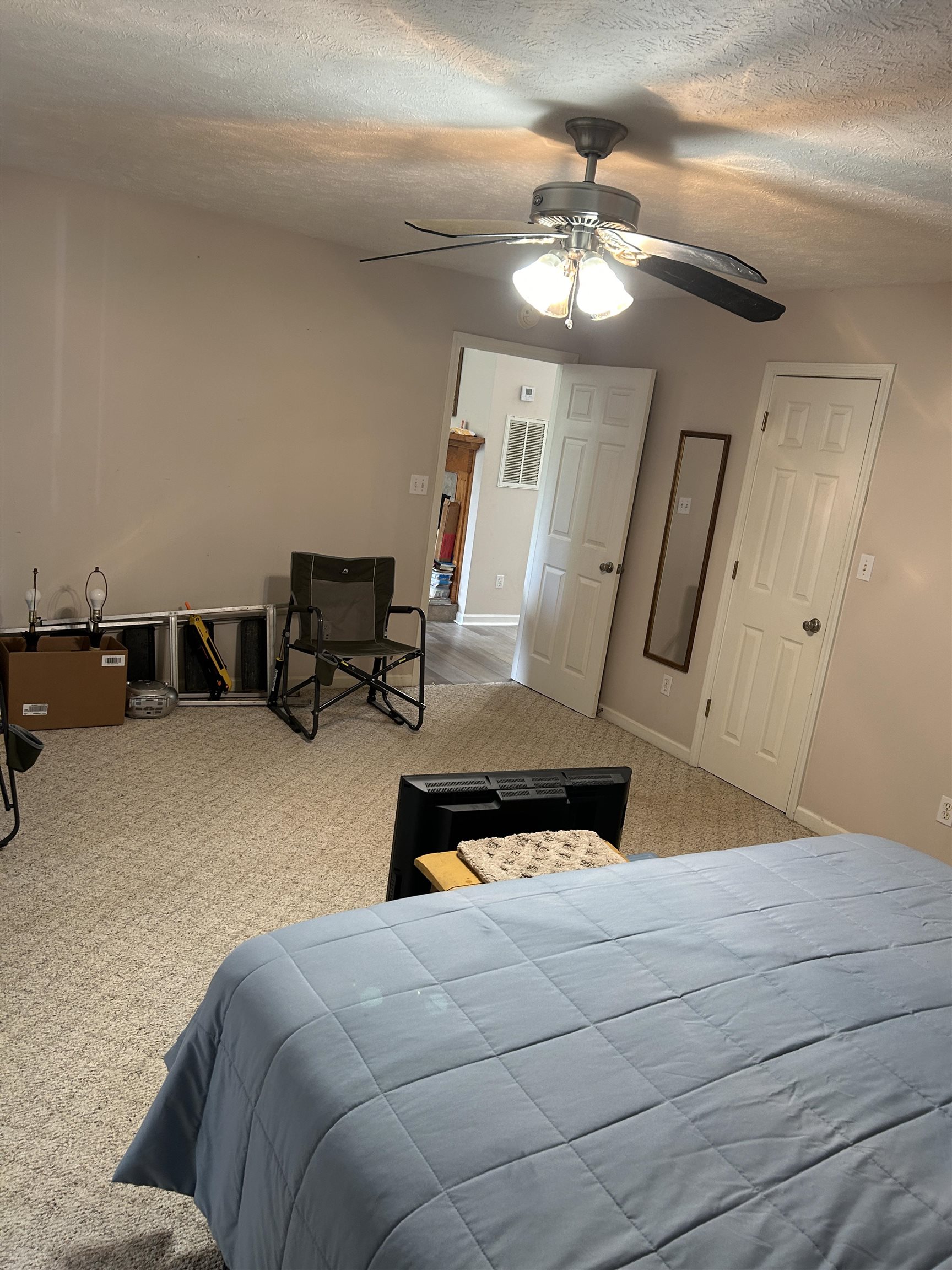 Bedroom featuring a textured ceiling, ceiling fan, and carpet