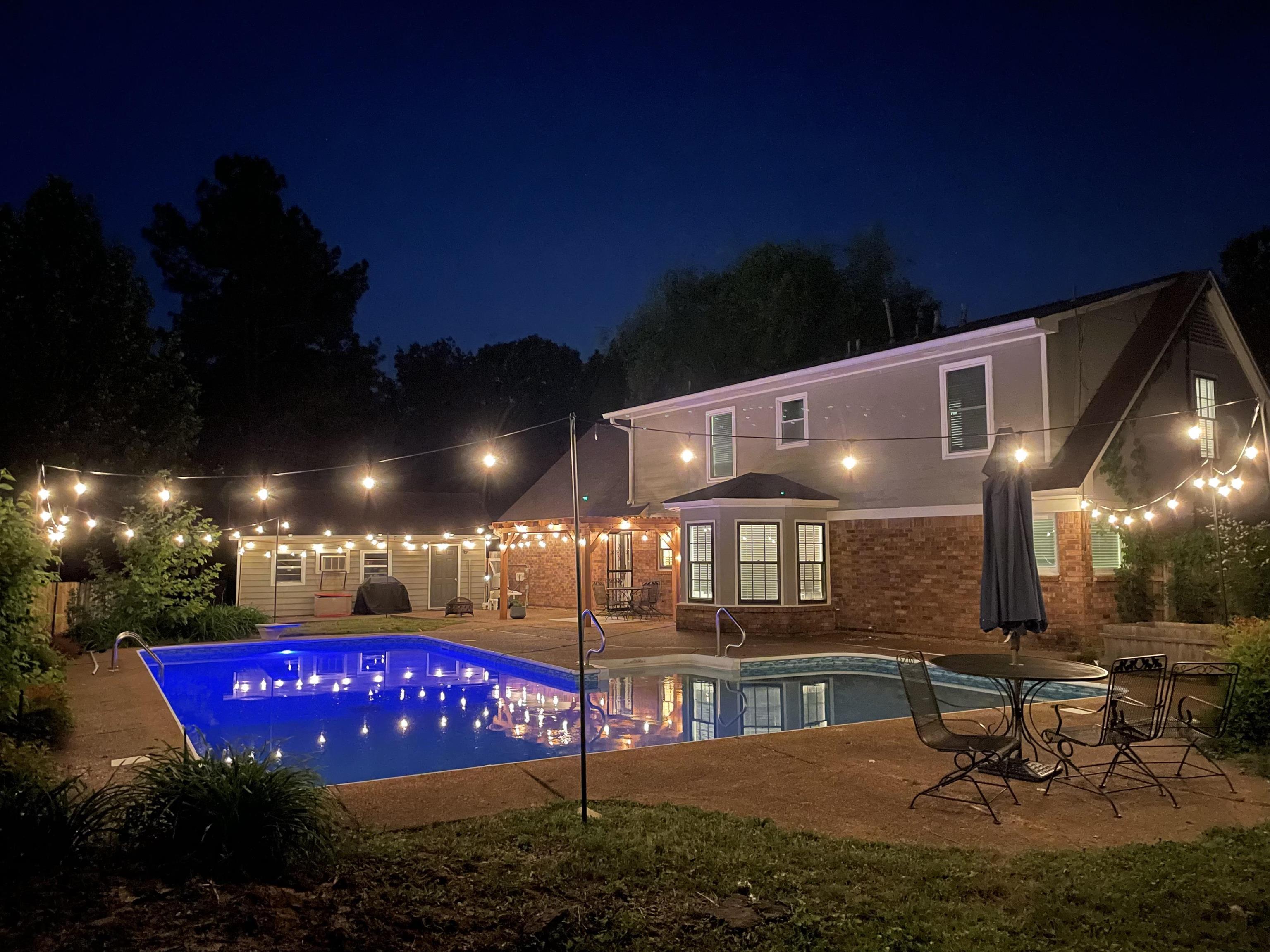 Pool at night featuring a patio