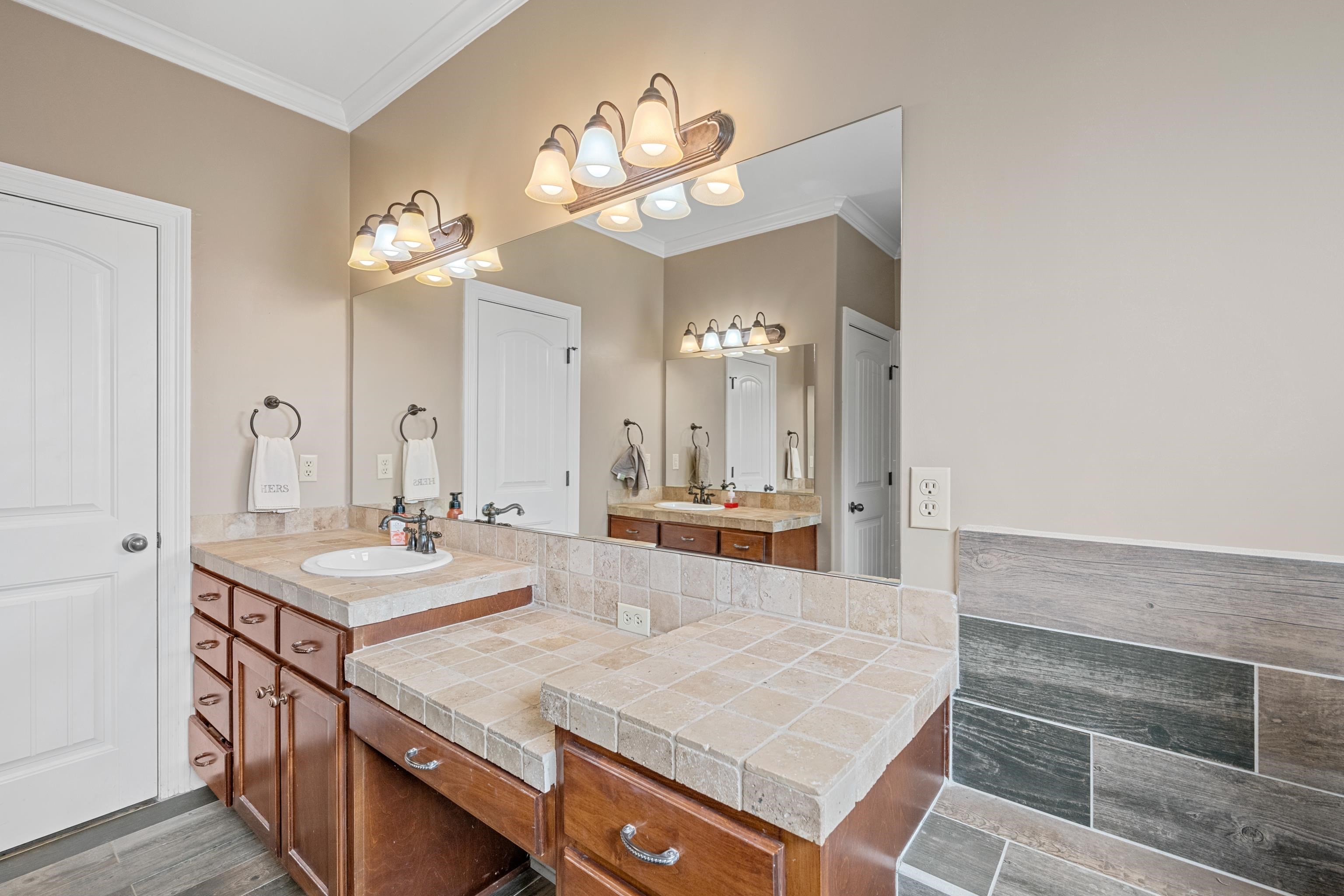 Bathroom featuring crown molding, vanity, and hardwood / wood-style flooring