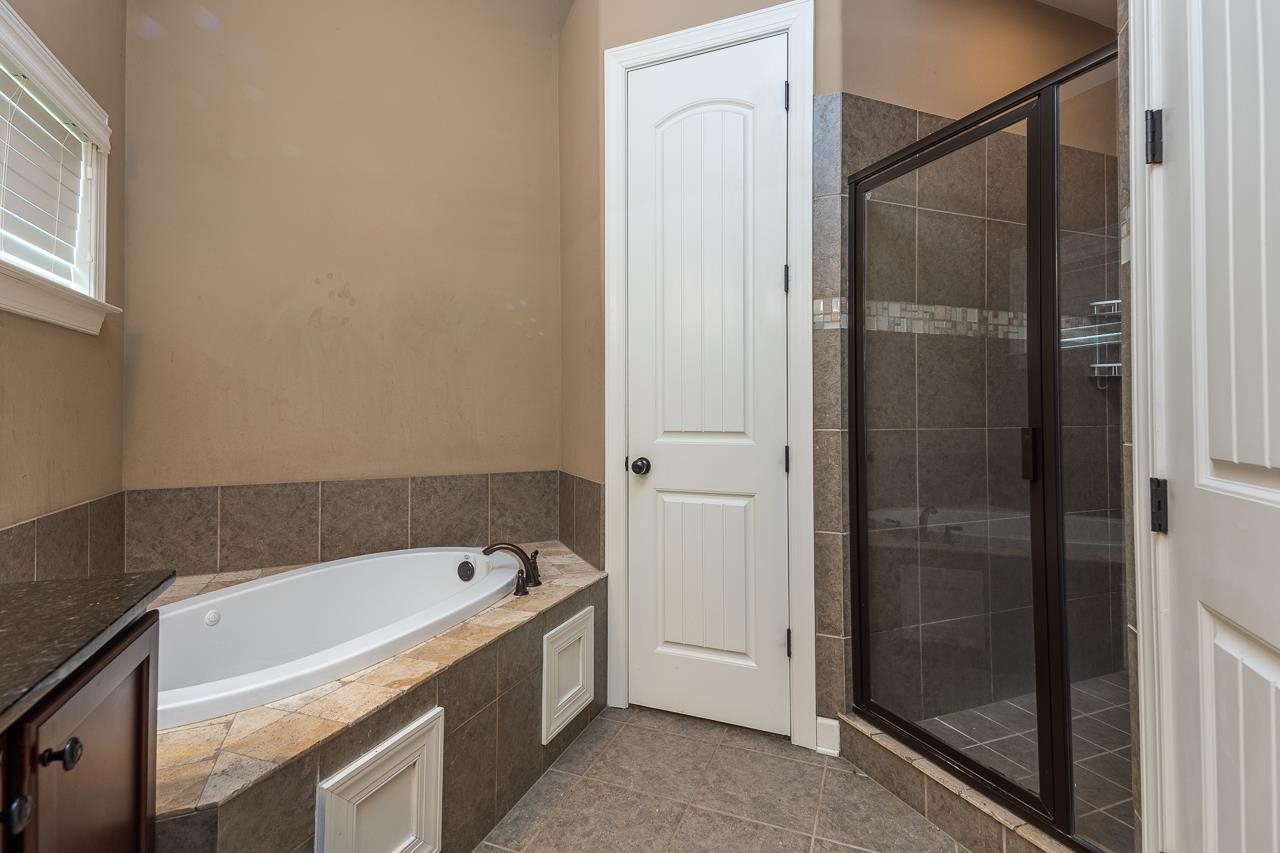 Bathroom with plus walk in shower, tile patterned floors, and vanity