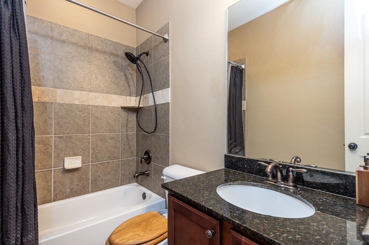 Full bathroom featuring vanity, toilet, and shower / bathtub combination with curtain