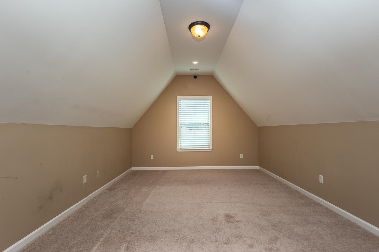 Bonus room featuring lofted ceiling and light colored carpet