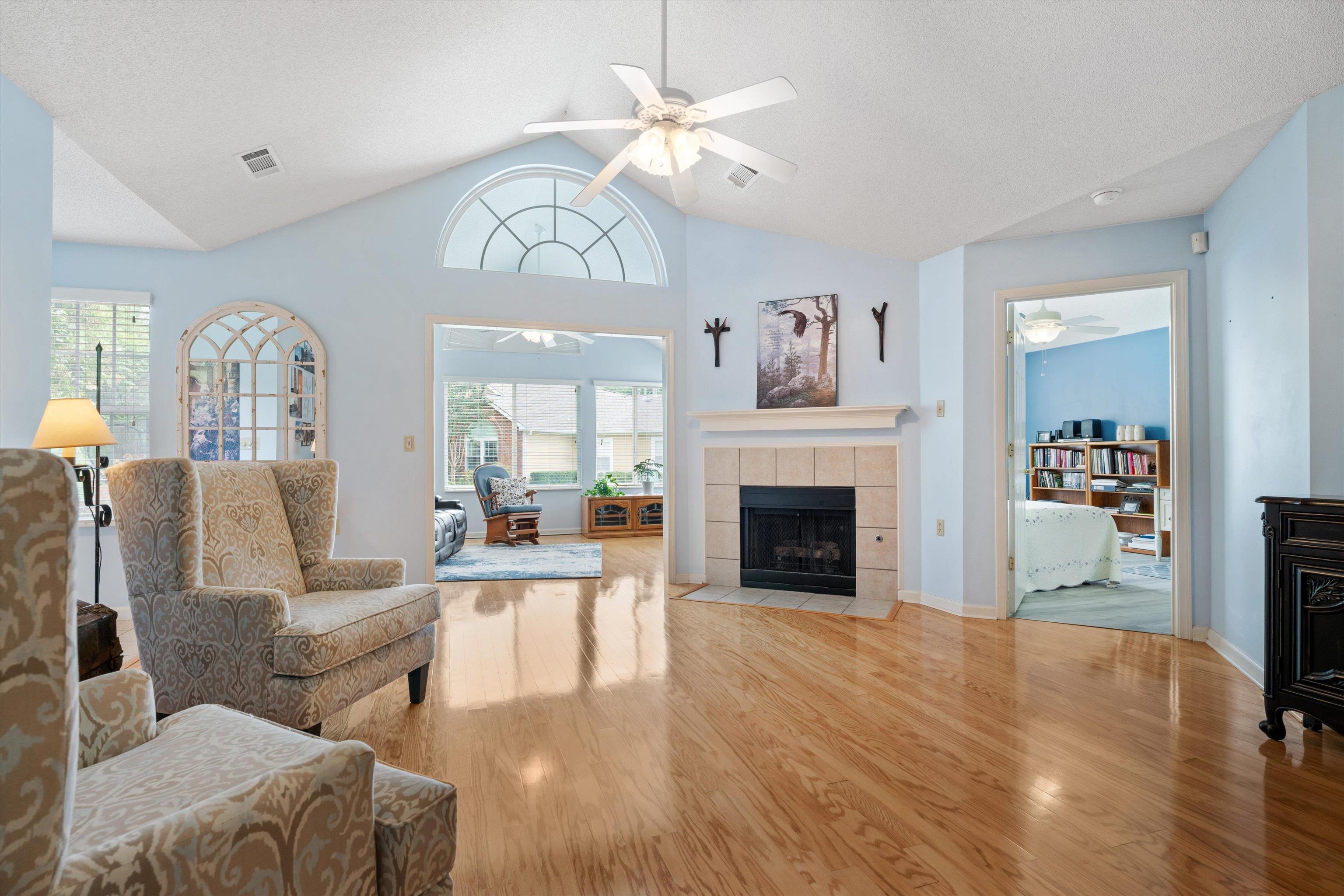 Living room featuring plenty of natural light, light hardwood / wood-style flooring, ceiling fan, and a tile fireplace