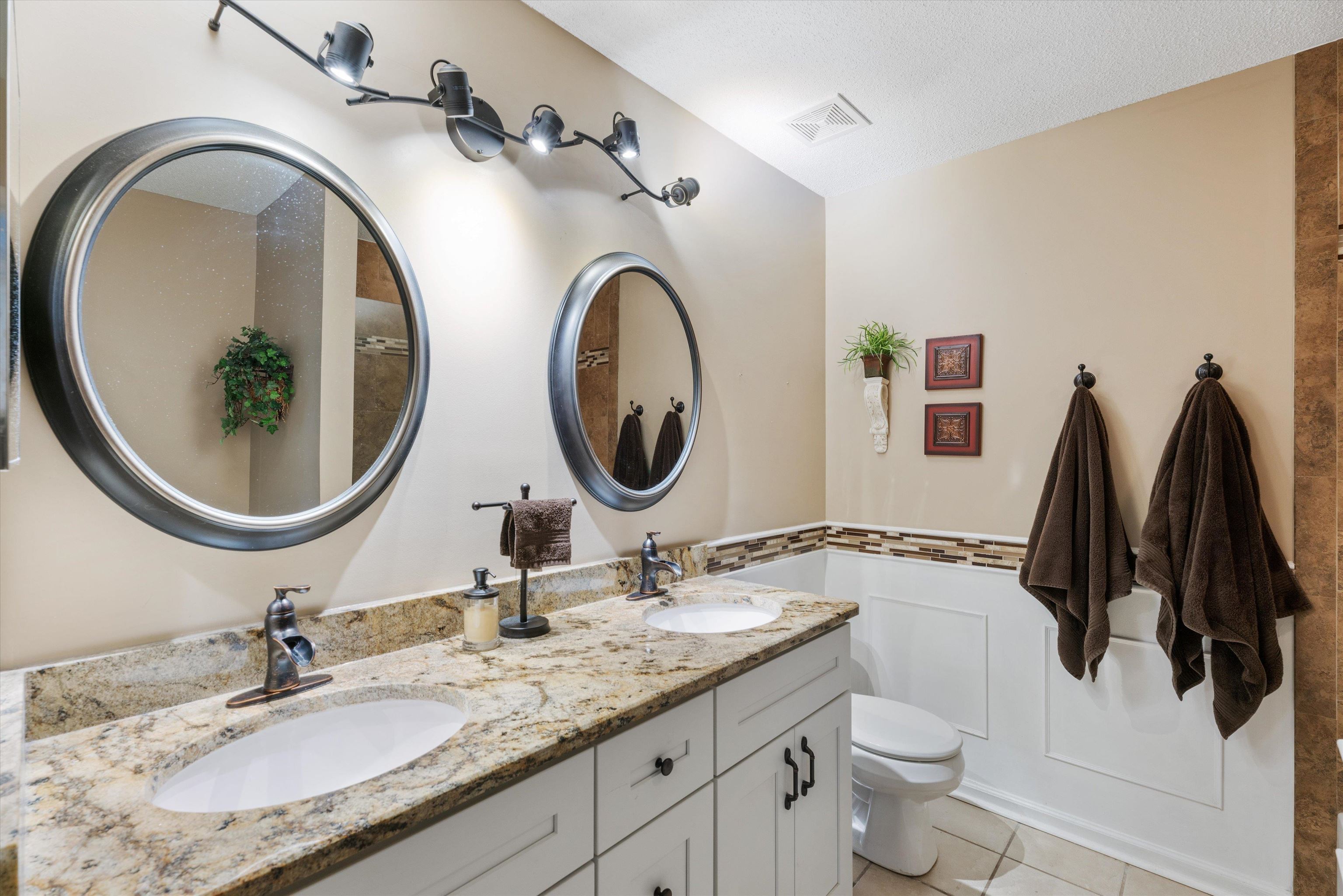 Bathroom with a textured ceiling, vanity, toilet, and tile patterned floors