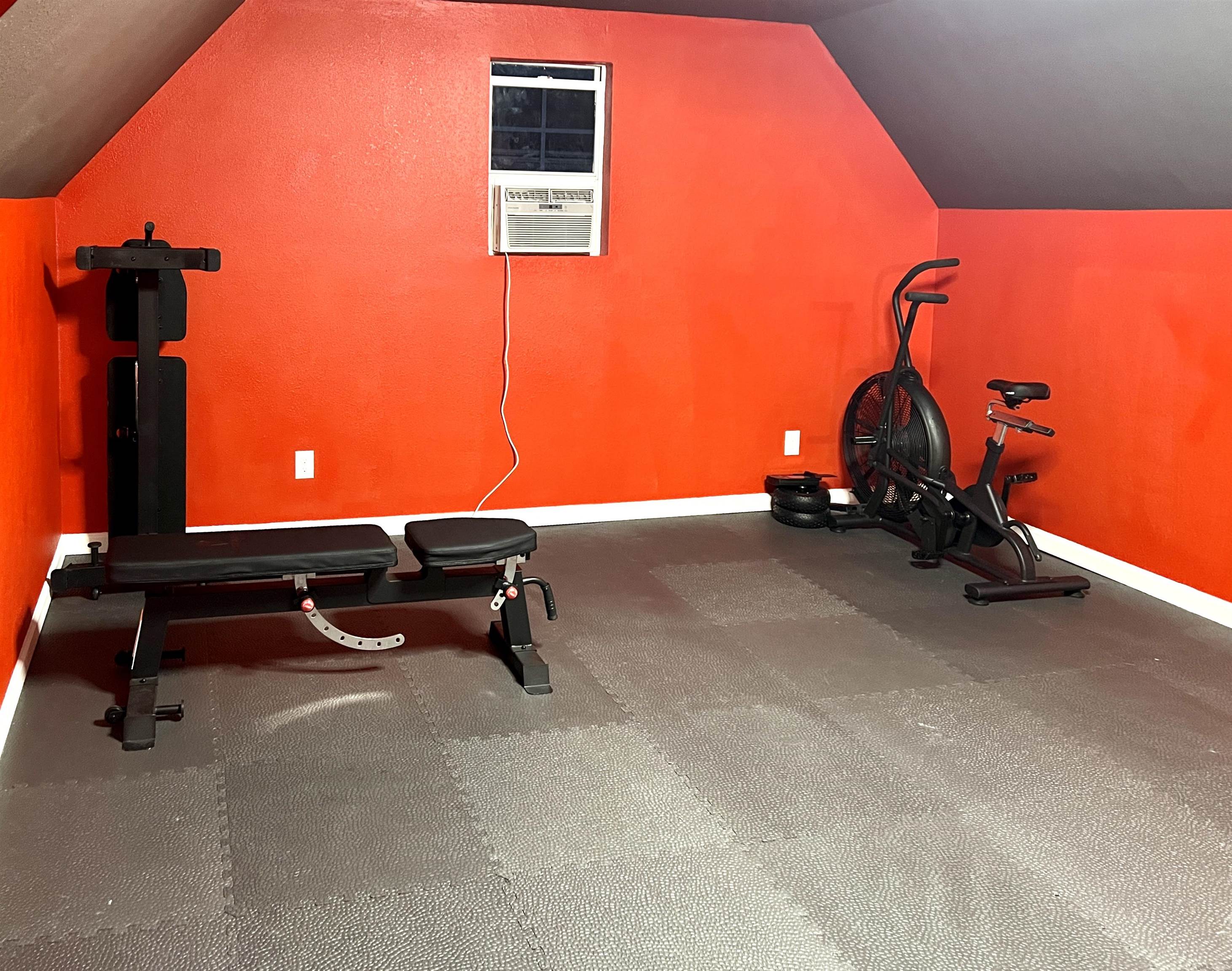 Bedroom is being used as home gym. Gym style mat flooring.