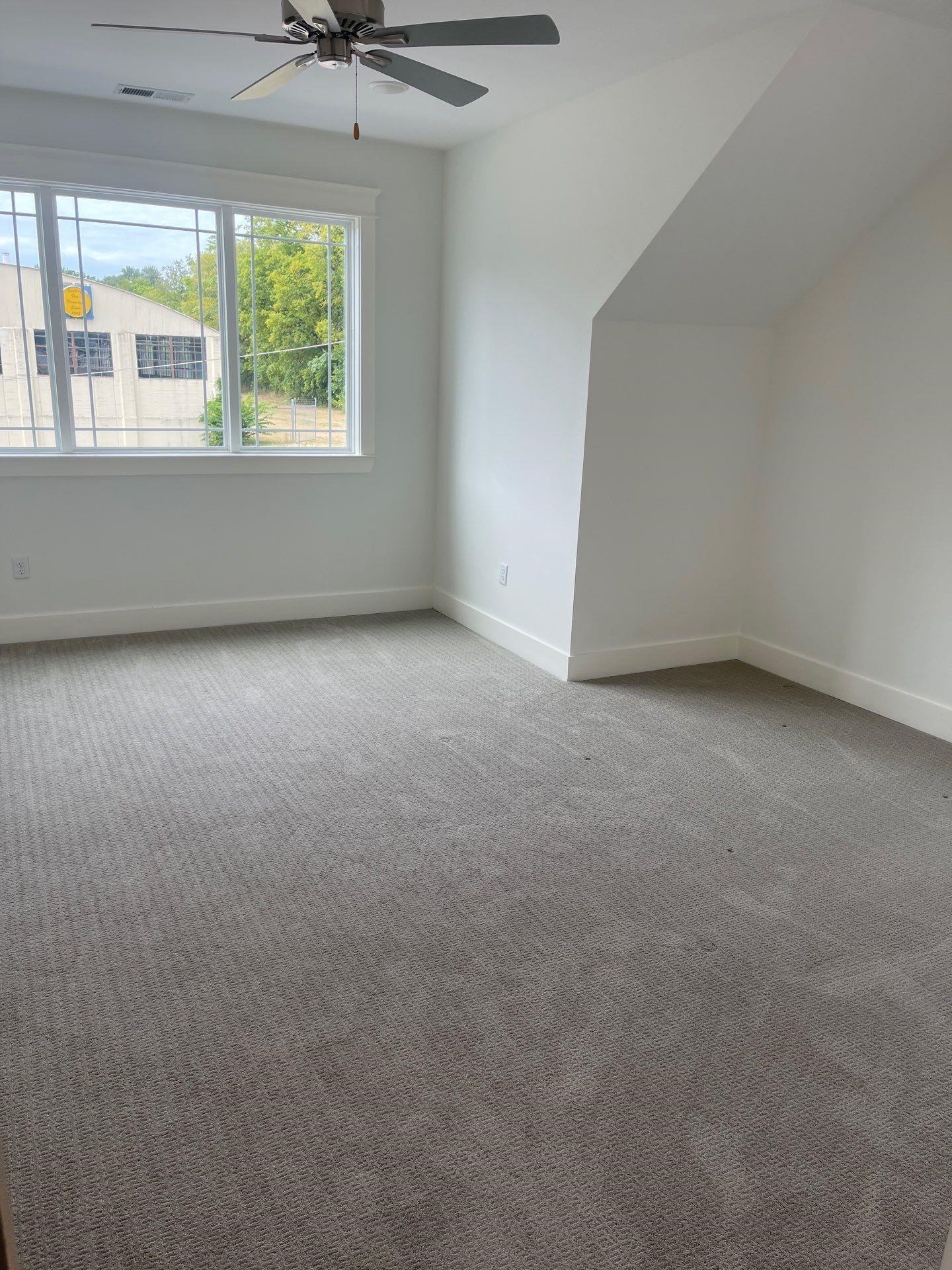 Carpeted spare room featuring lofted ceiling and ceiling fan