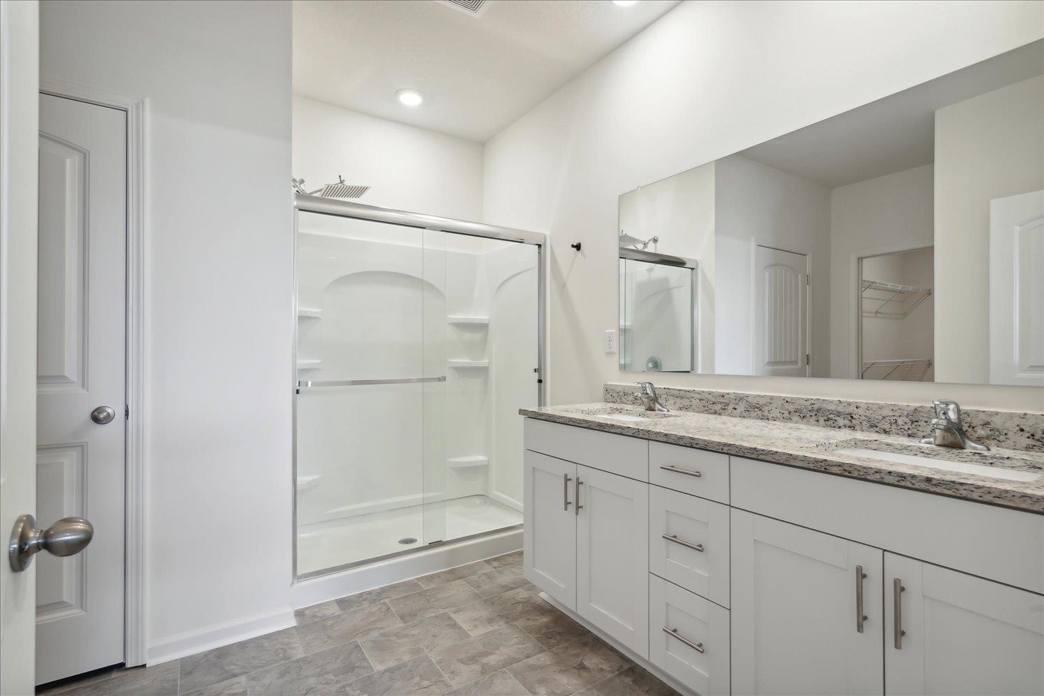 Bathroom with vanity and a shower with shower door