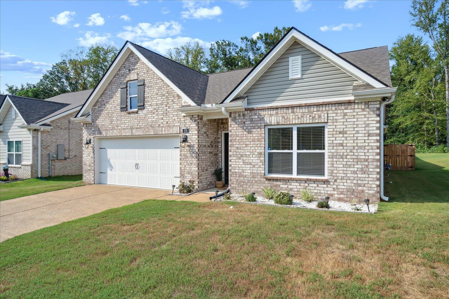 View of front of home with a garage and a front lawn