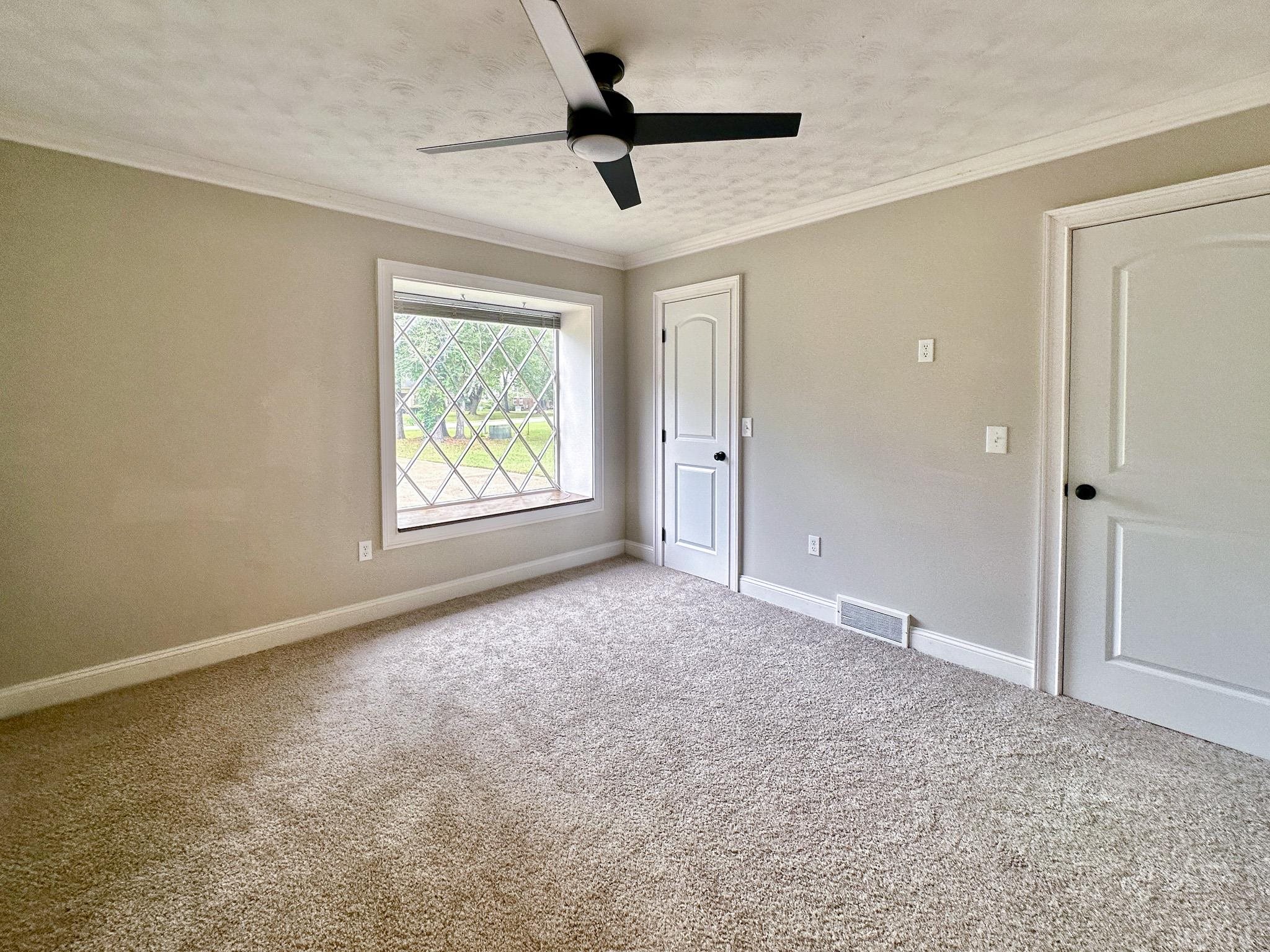 The downstairs front bedroom features new carpet, fresh paint and a shared half bath.