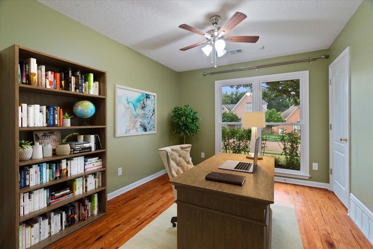 Office featuring light wood-type flooring, a healthy amount of sunlight, and ceiling fan