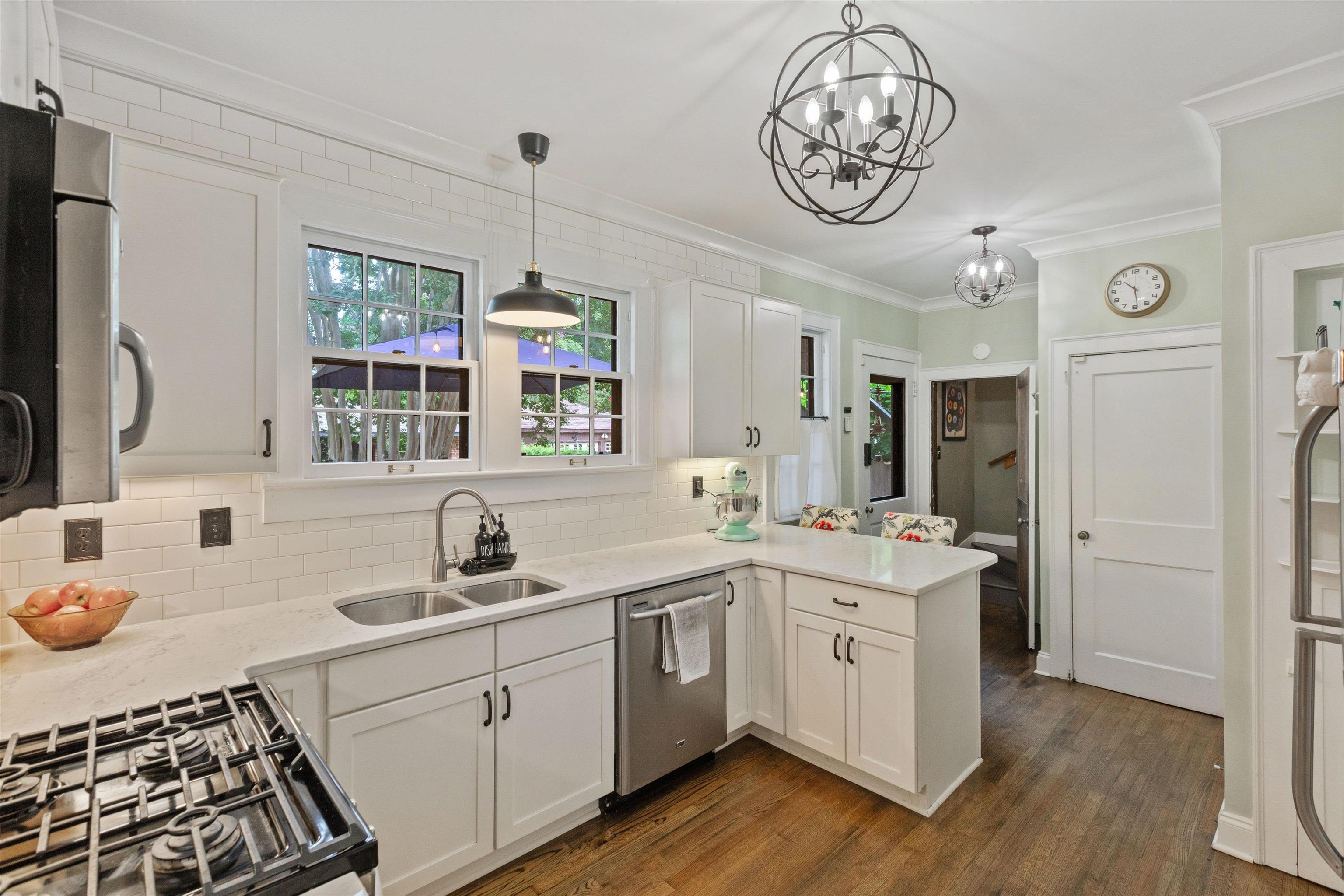 Kitchen featuring decorative light fixtures, appliances with stainless steel finishes.