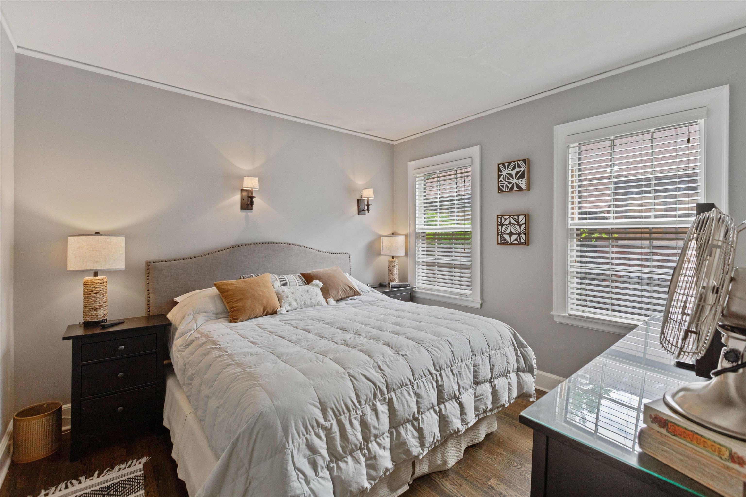 Bedroom with crown molding and dark wood flooring