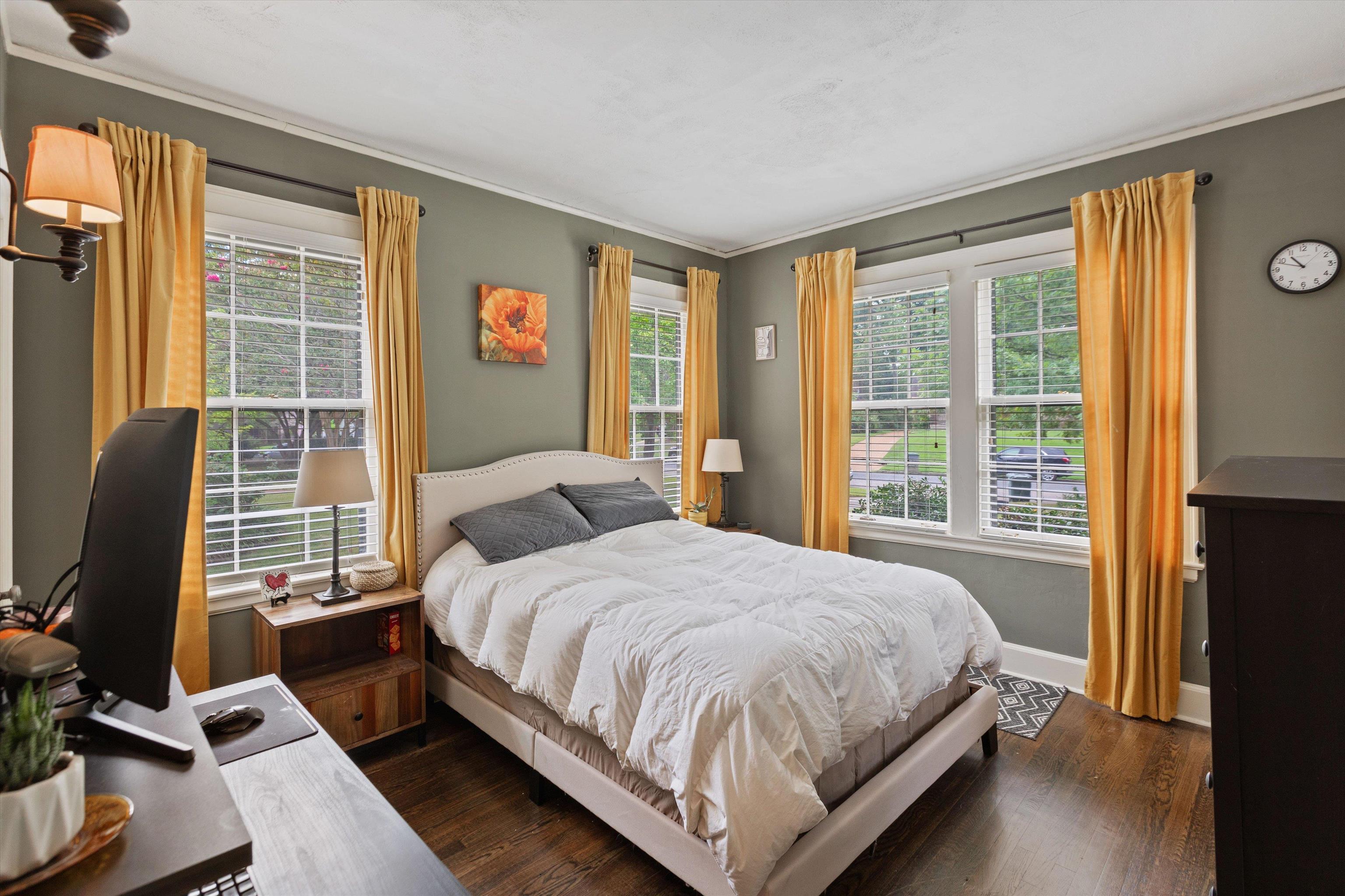 Bedroom with crown molding and dark wood flooring