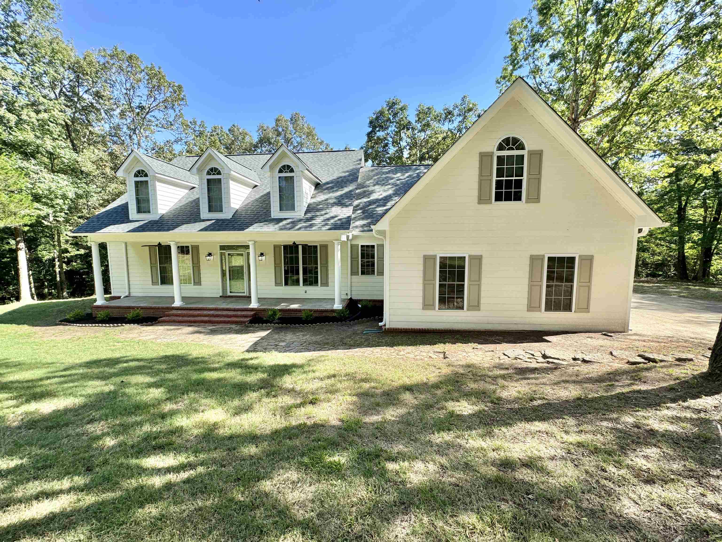 New england style home featuring a front lawn and a porch