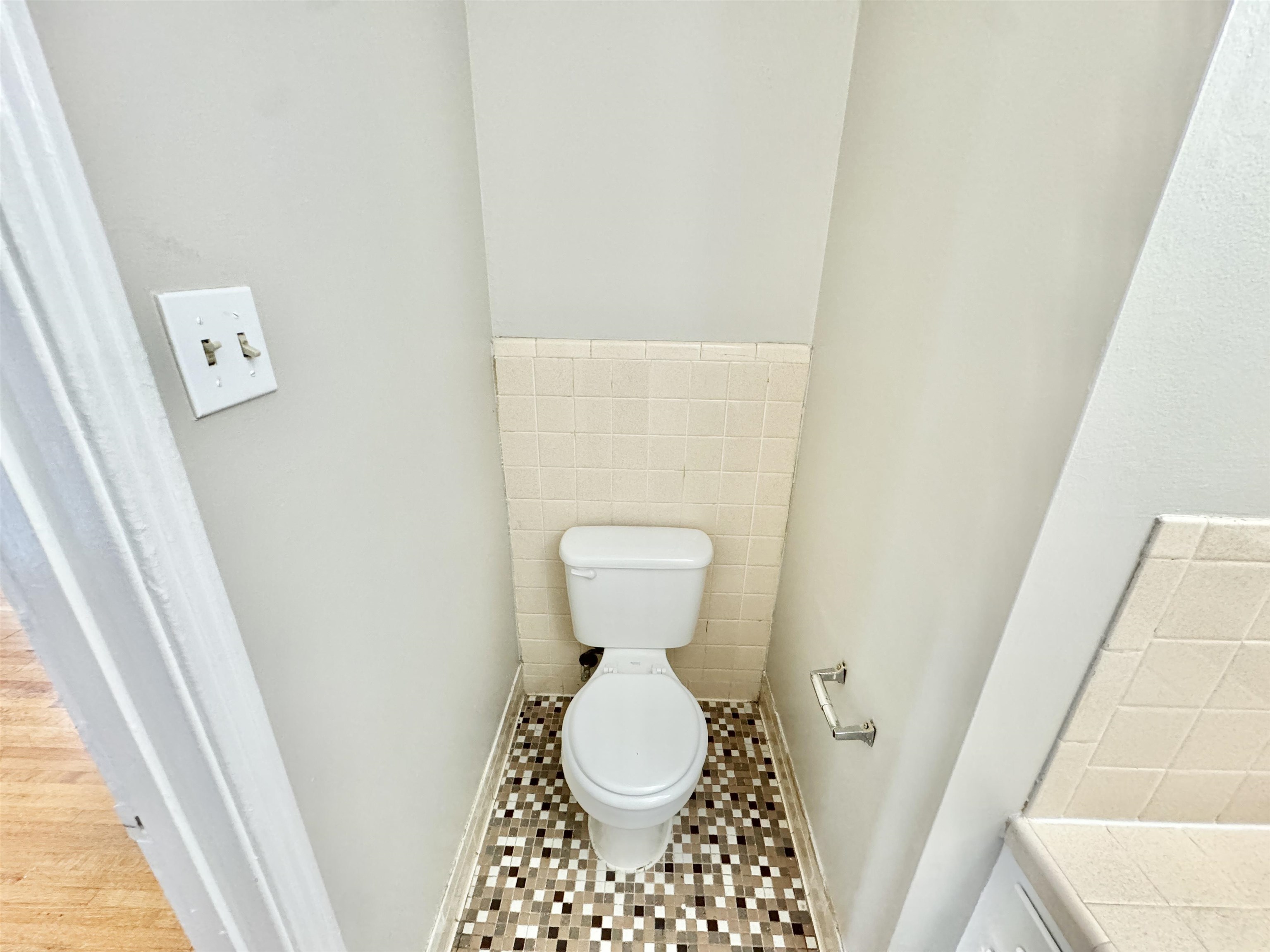 Bathroom featuring tile walls, toilet, and tile patterned floors