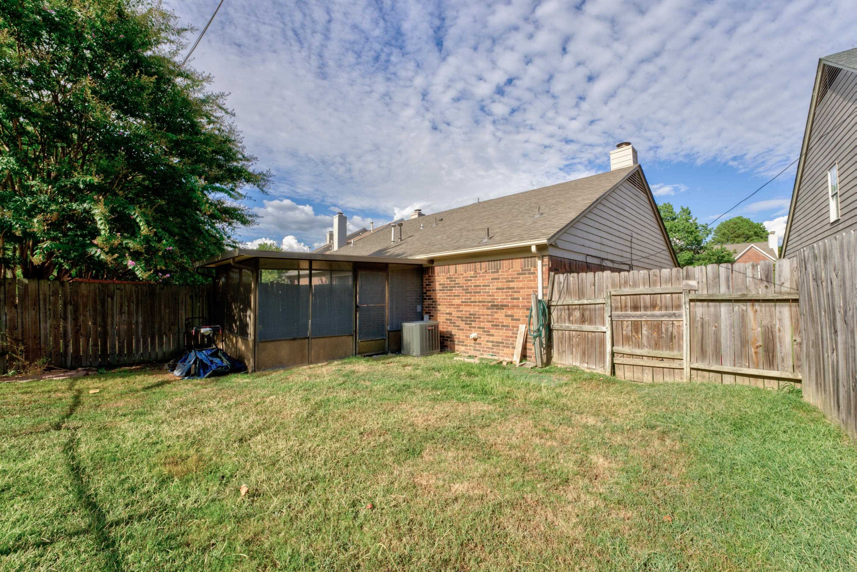 View of yard featuring central AC and a sunroom