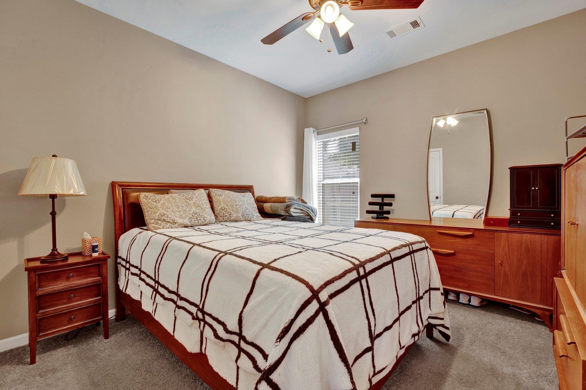 Carpeted bedroom with ceiling fan