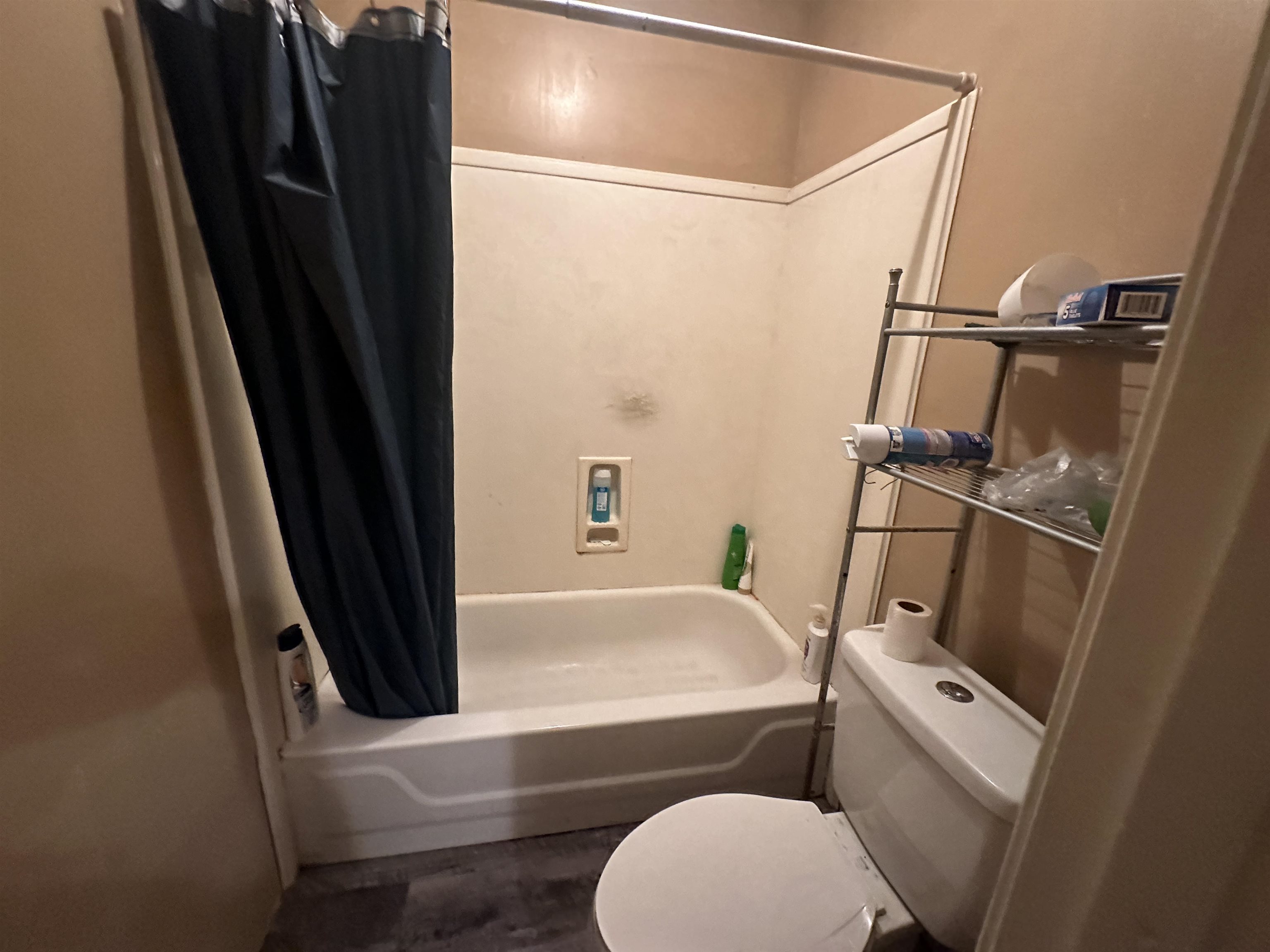 Bathroom featuring toilet and shower / bath combo with shower curtain