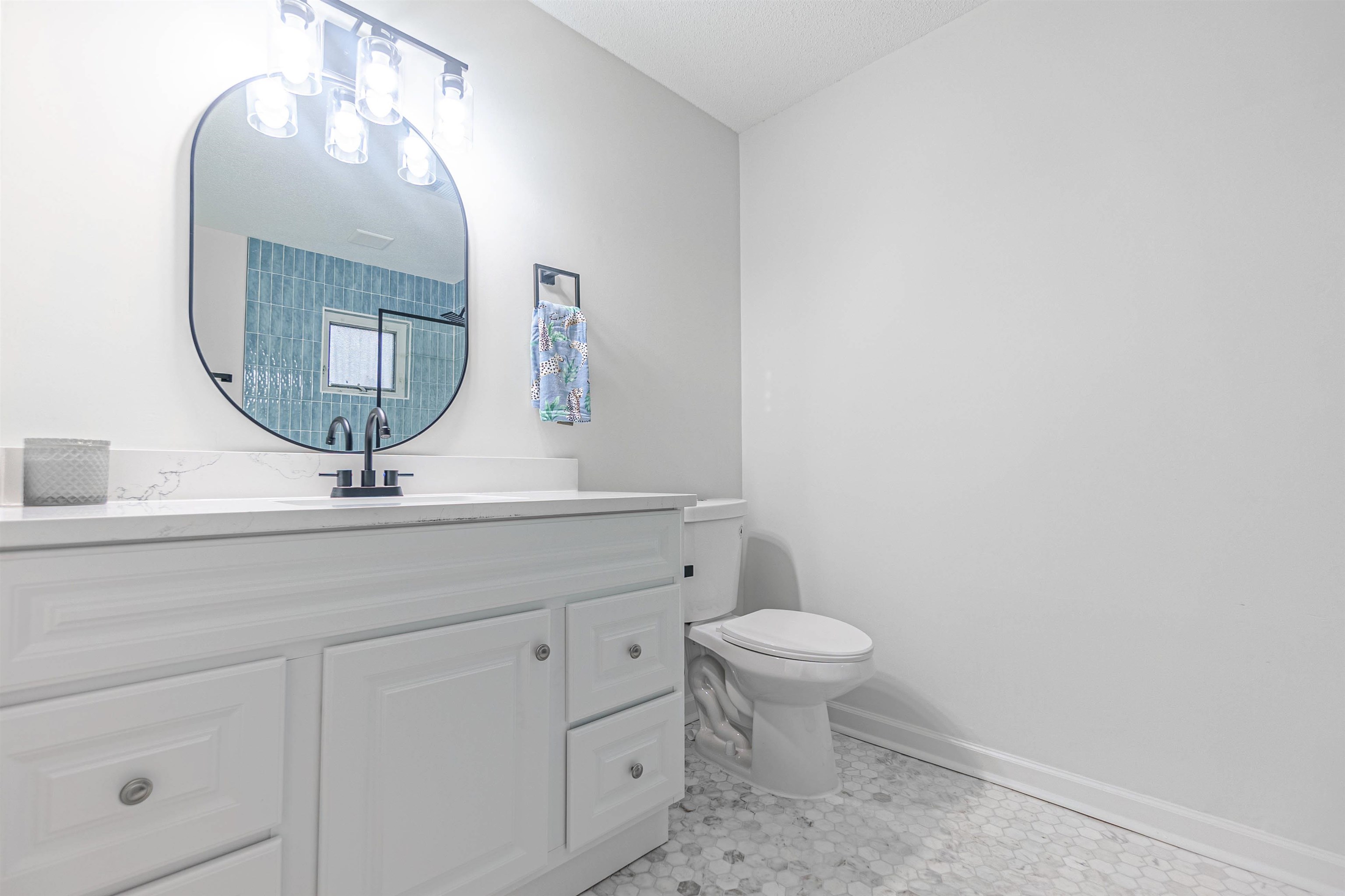 Bathroom featuring tile patterned flooring, vanity, and toilet