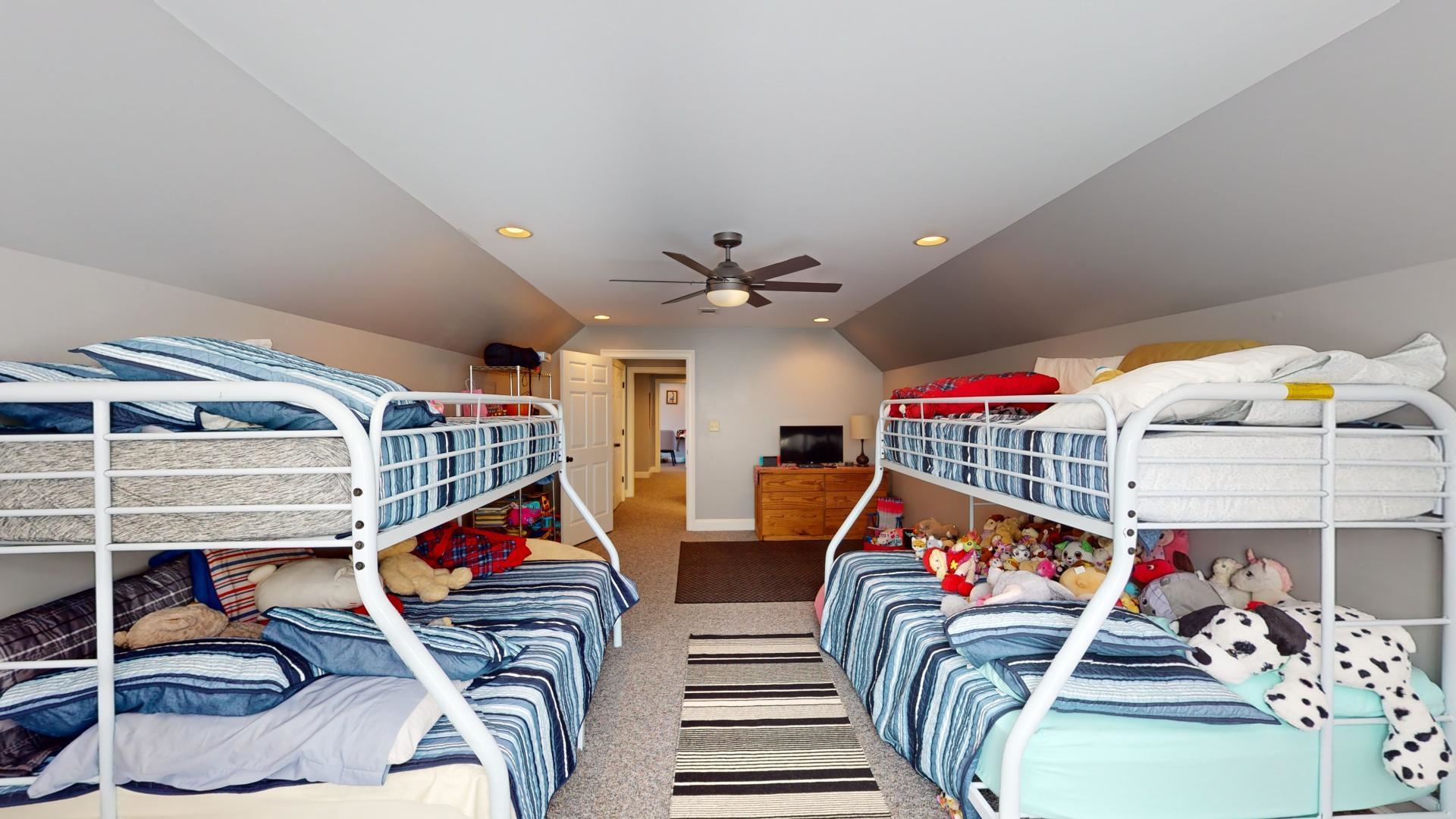 Carpeted bedroom with lofted ceiling and ceiling fan