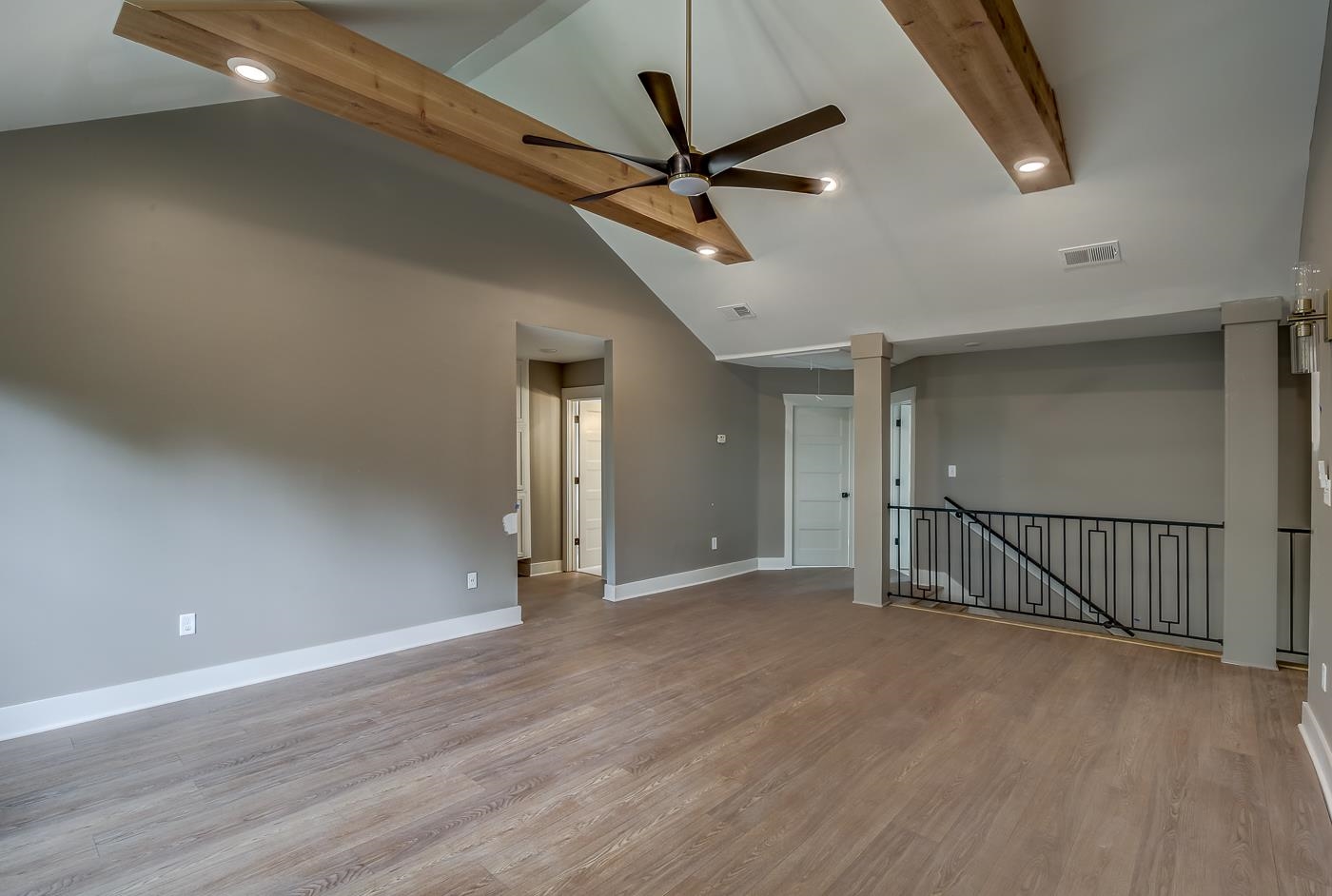 Empty room featuring light wood-type flooring, ceiling fan, and high vaulted ceiling