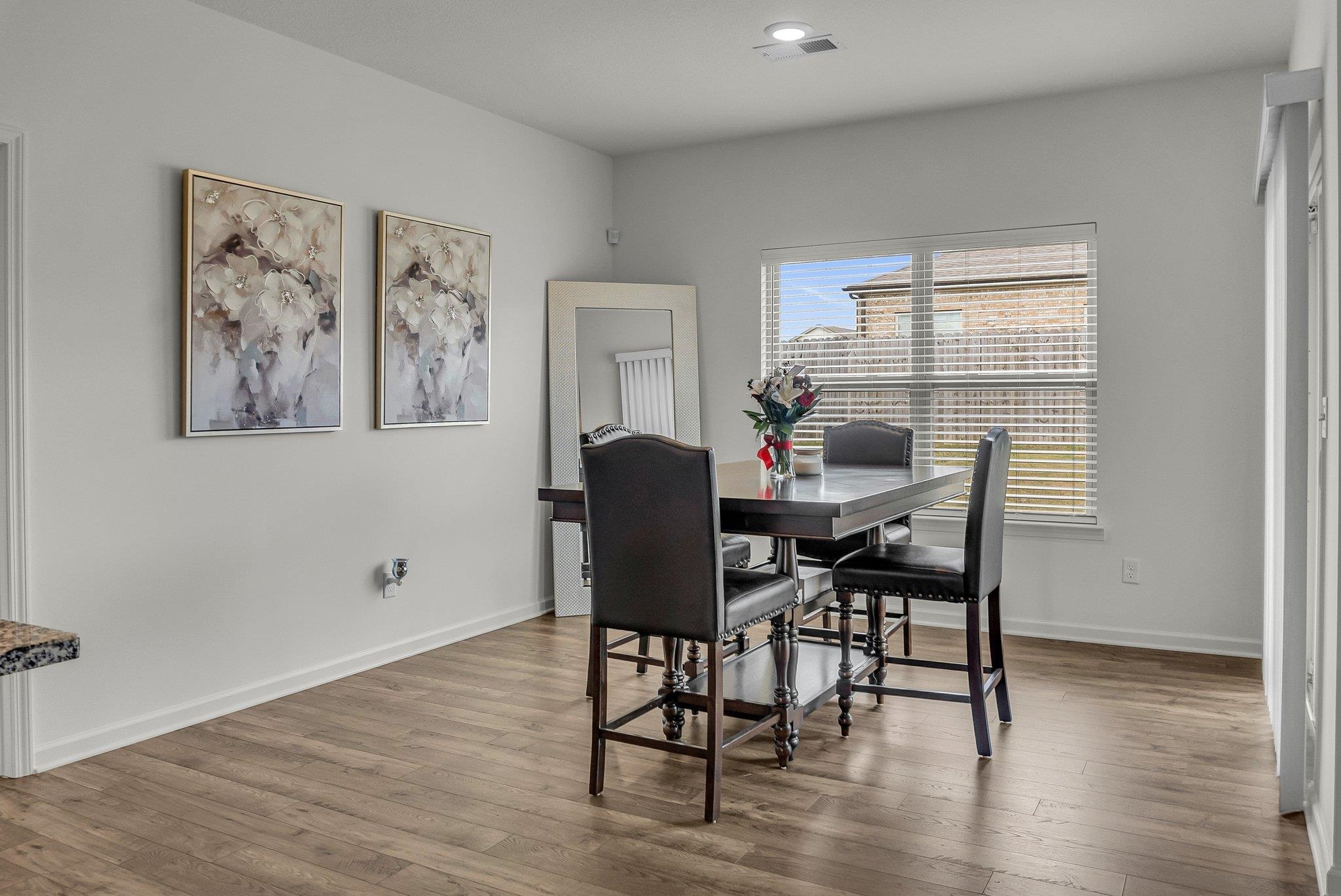 The dining area highlights elegant hardwood or wood-style flooring, adding warmth and charm to the space.