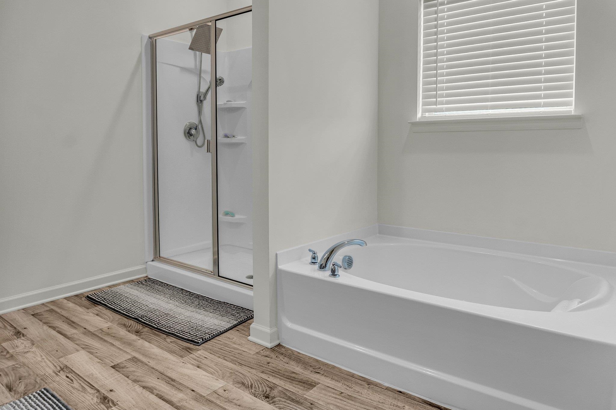 Bathroom featuring hardwood / wood-style flooring and independent shower and bath