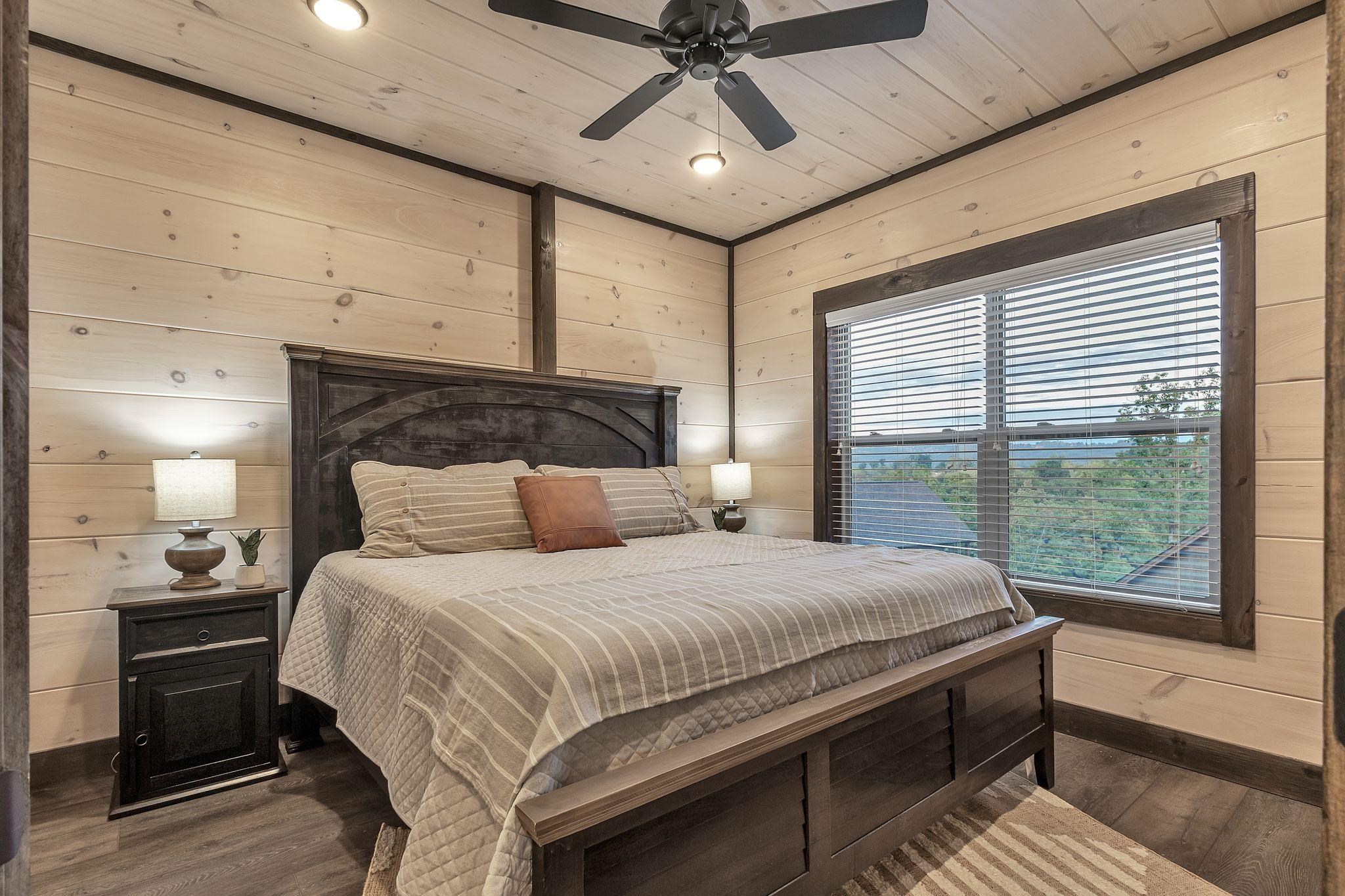 Bedroom featuring wood walls, ceiling fan, dark hardwood / wood-style flooring, and wooden ceiling