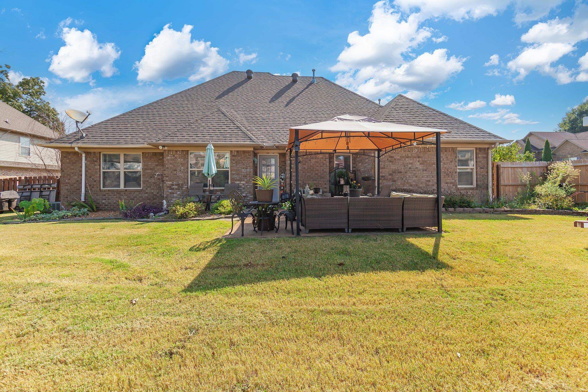 Back of house with a lawn, a patio area, outdoor lounge area, and a gazebo