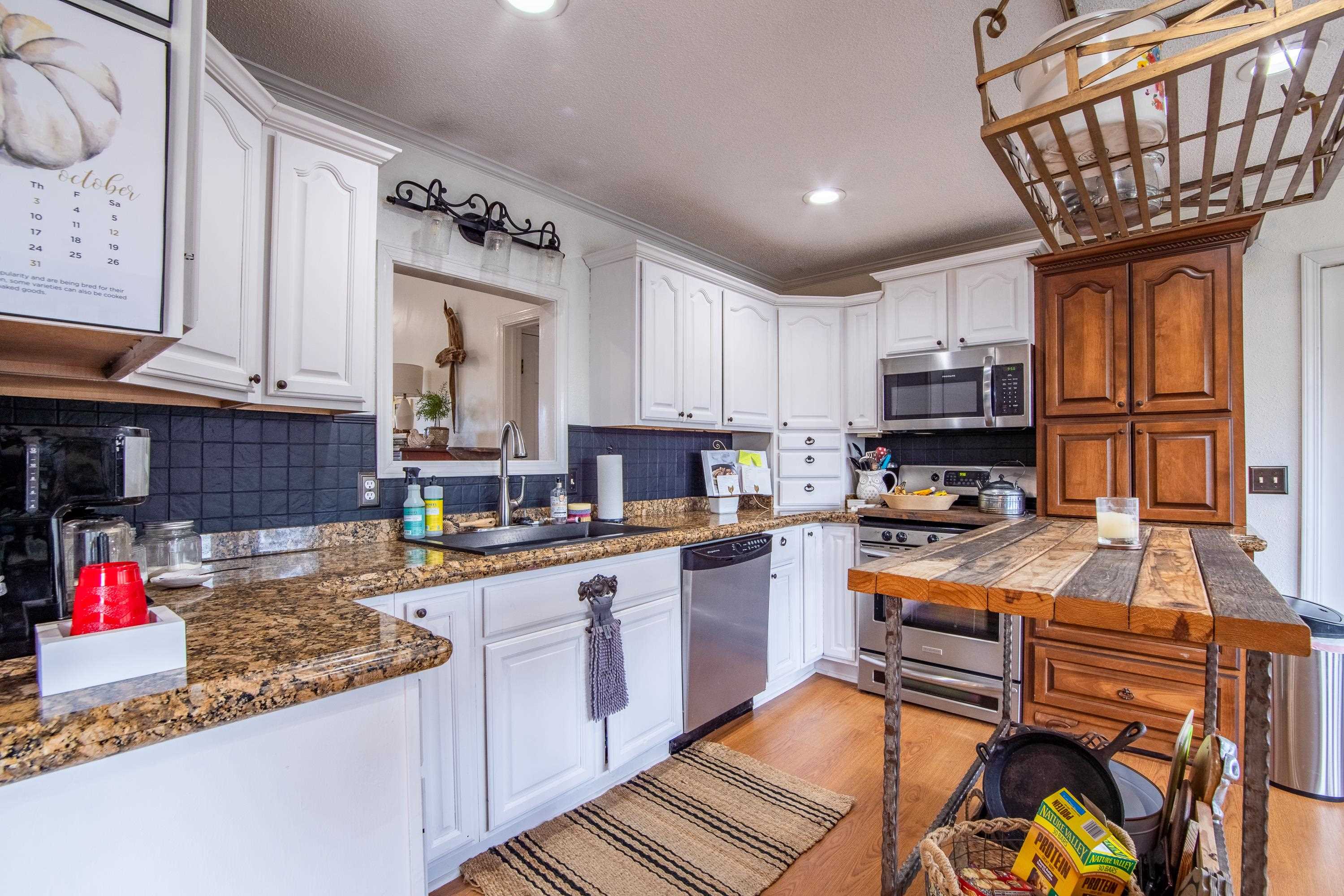 Kitchen featuring light hardwood / wood-style flooring, stainless steel appliances, granite countertops, and beautiful cabinetry