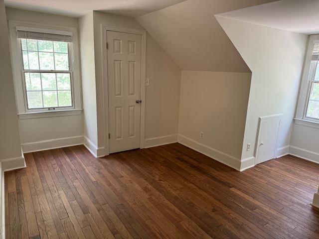 Additional living space featuring dark hardwood / wood-style floors and vaulted ceiling