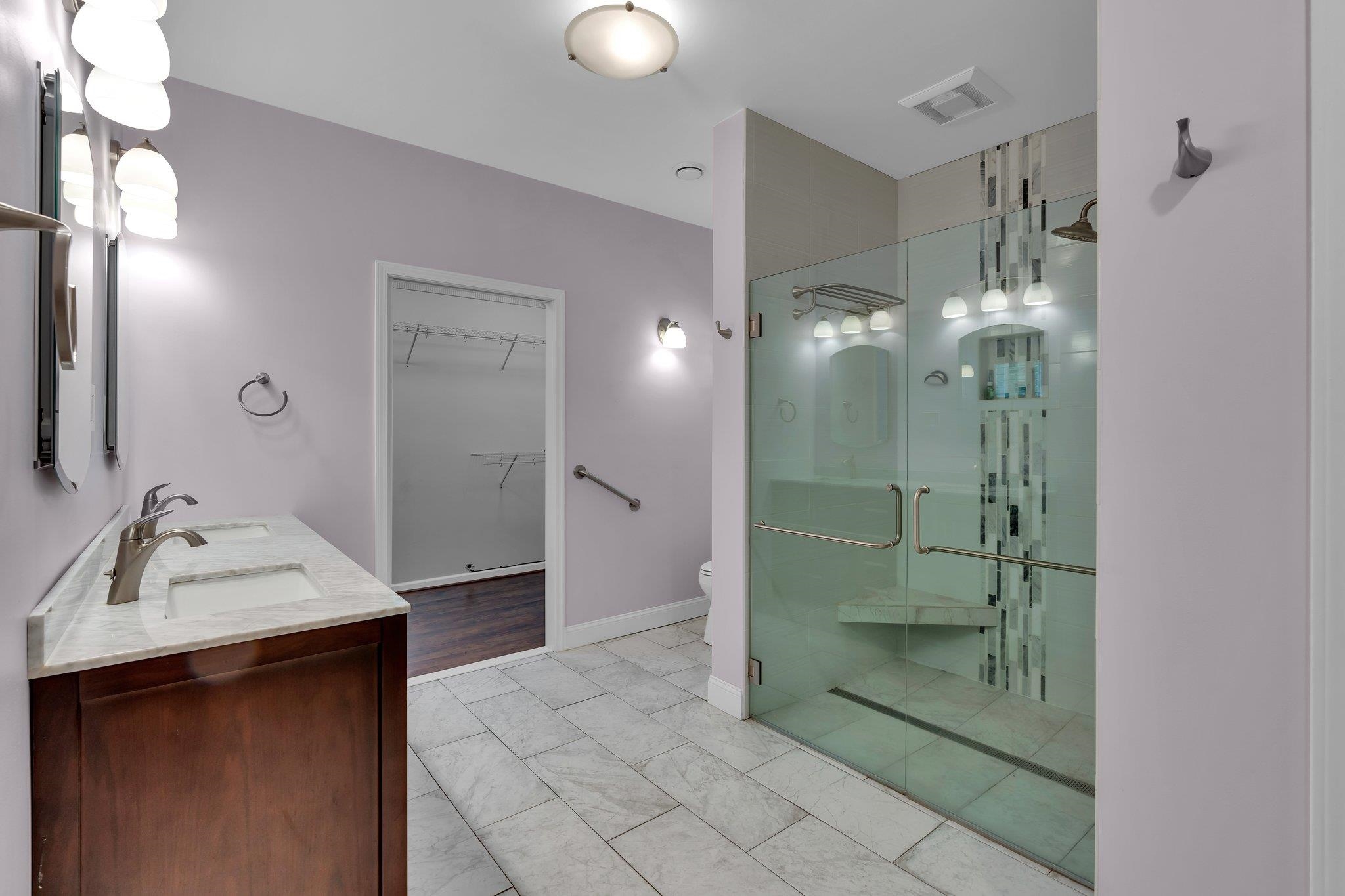 Bathroom featuring an enclosed shower, toilet, and vanity