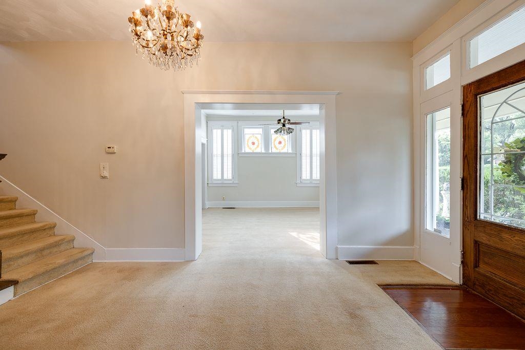 Foyer with ceiling fan with notable chandelier, wood-type flooring, and a wealth of natural light