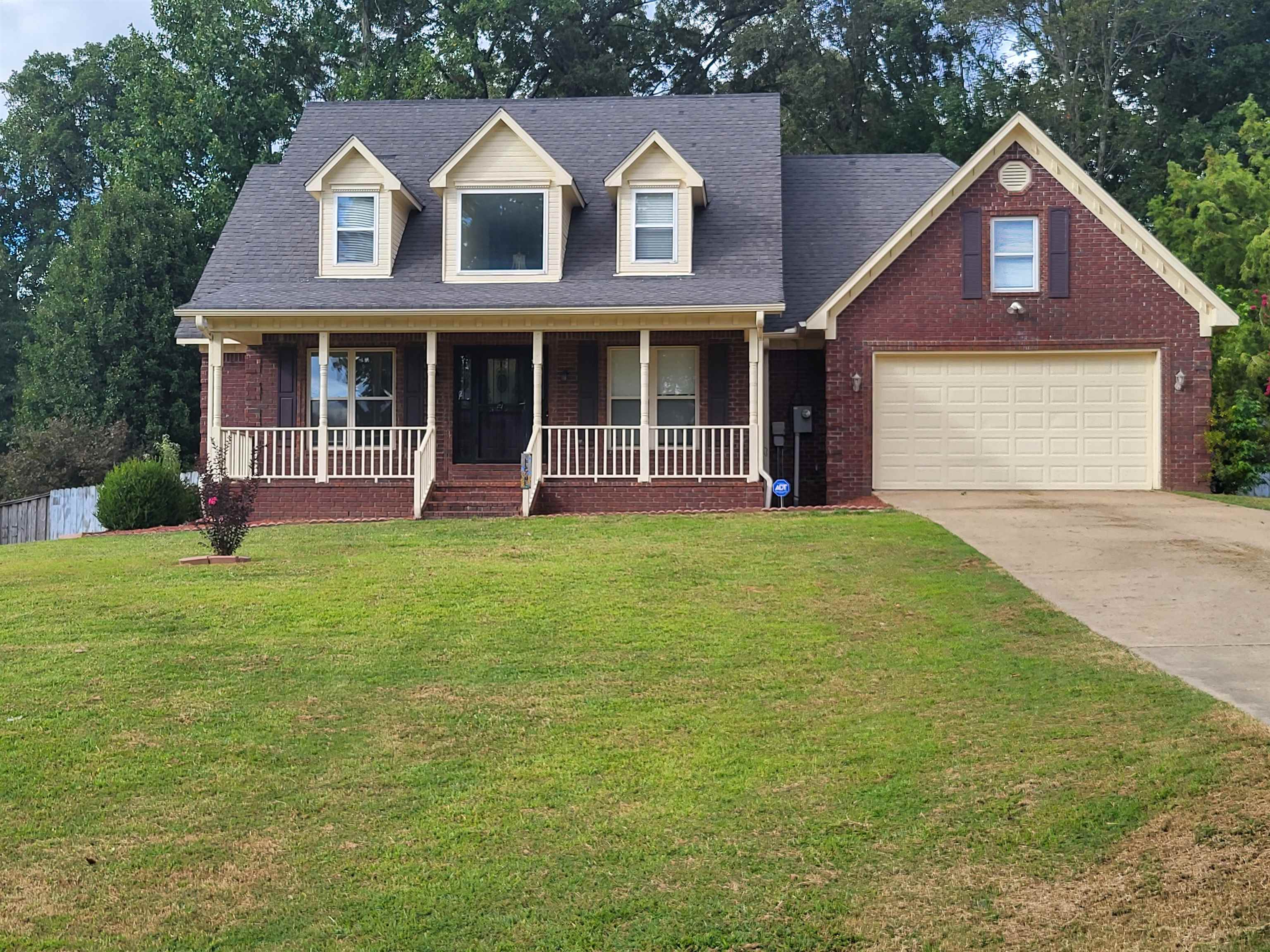 Cape cod-style house with a front lawn and covered porch