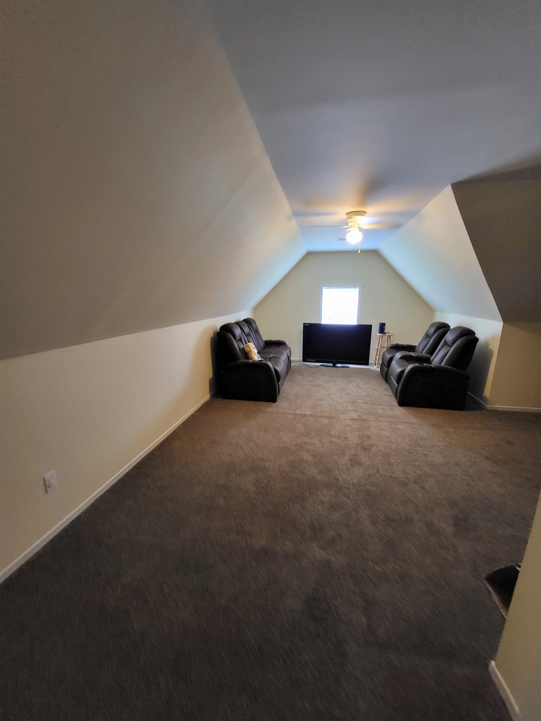 Bonus room with lofted ceiling, carpet, and ceiling fan