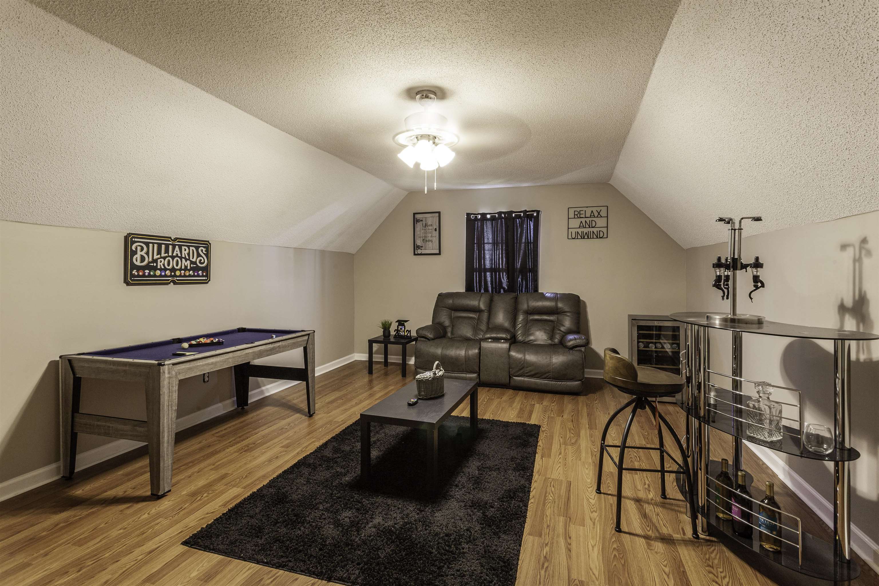 Interior space featuring a textured ceiling, vaulted ceiling, hardwood / wood-style floors, and ceiling fan