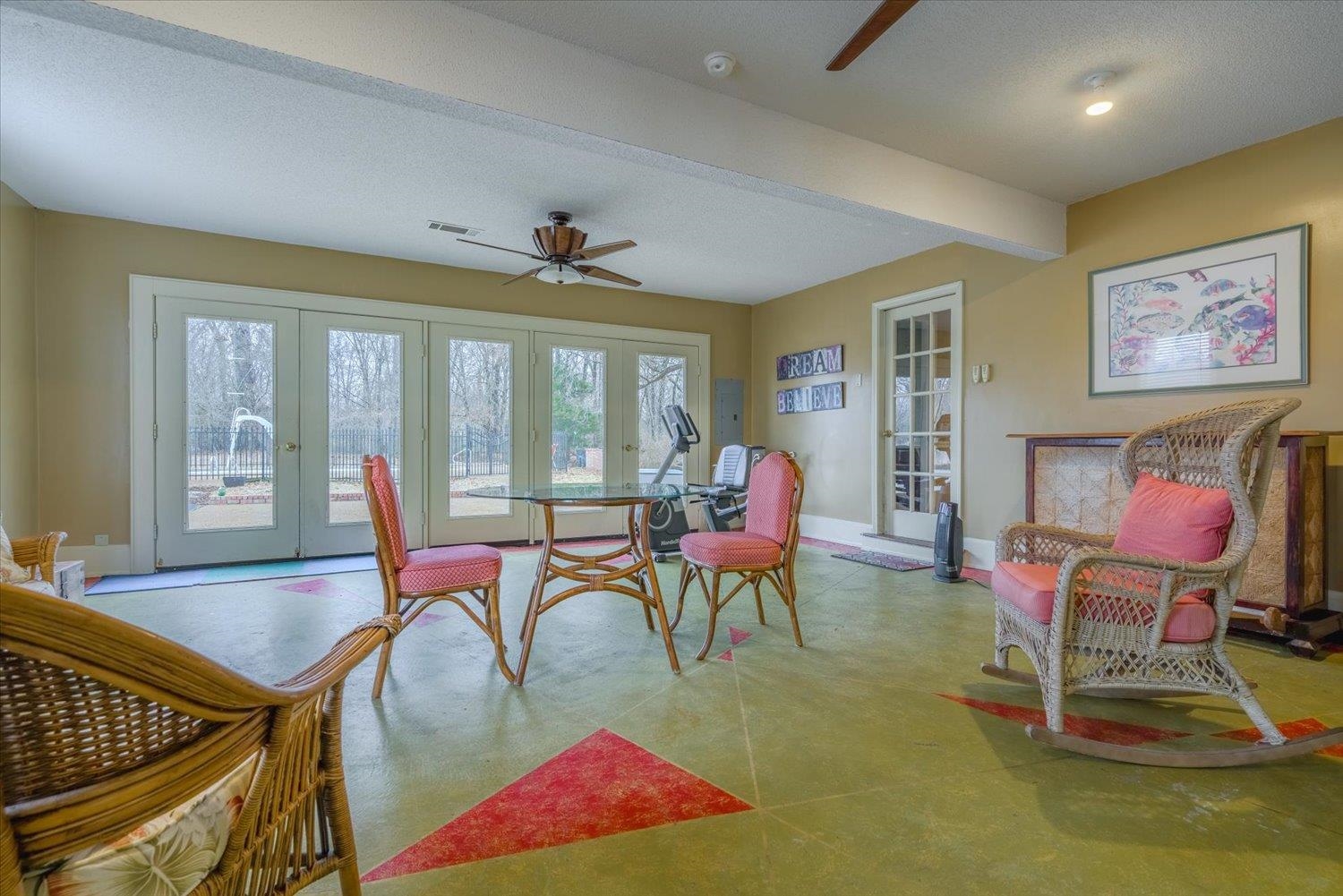 Dining space featuring french doors, beamed ceiling, ceiling fan, and a textured ceiling