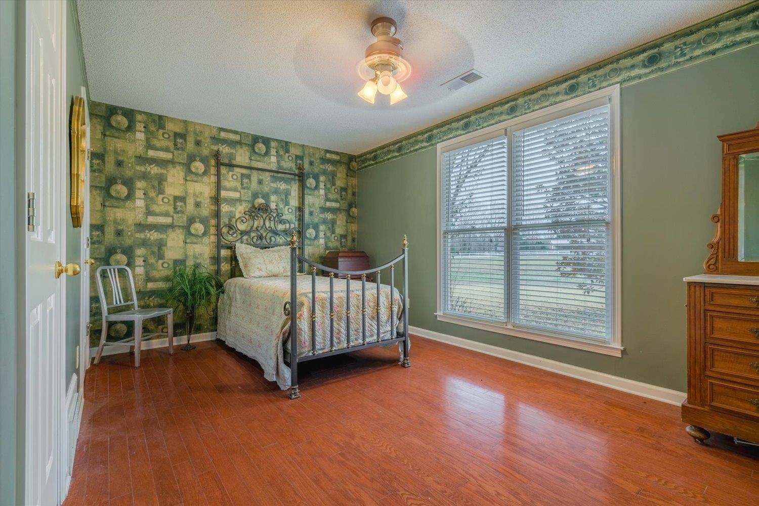 Bedroom featuring a textured ceiling, hardwood / wood-style flooring, and ceiling fan