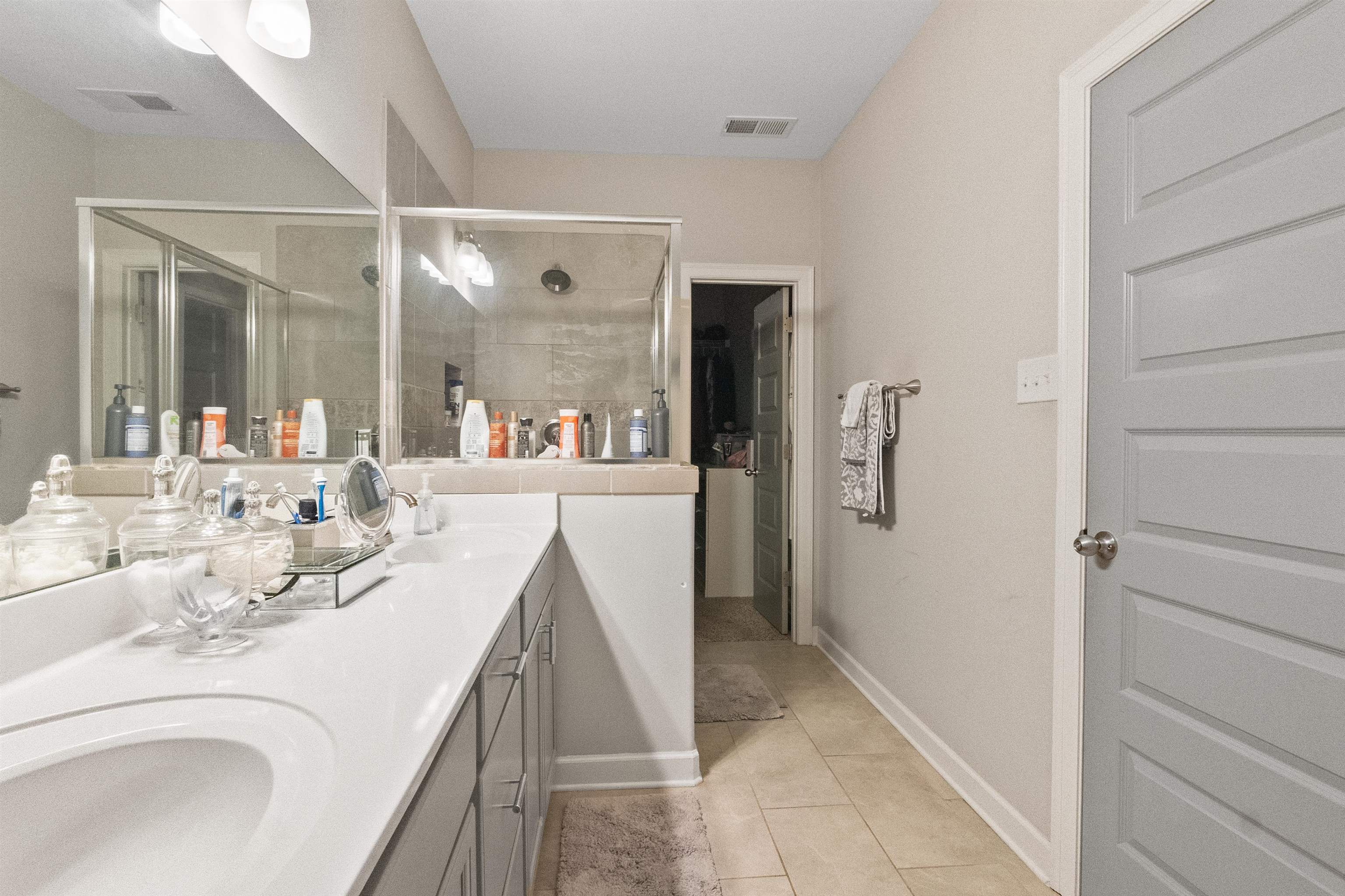 Bathroom with tile patterned floors, walk in shower, and vanity