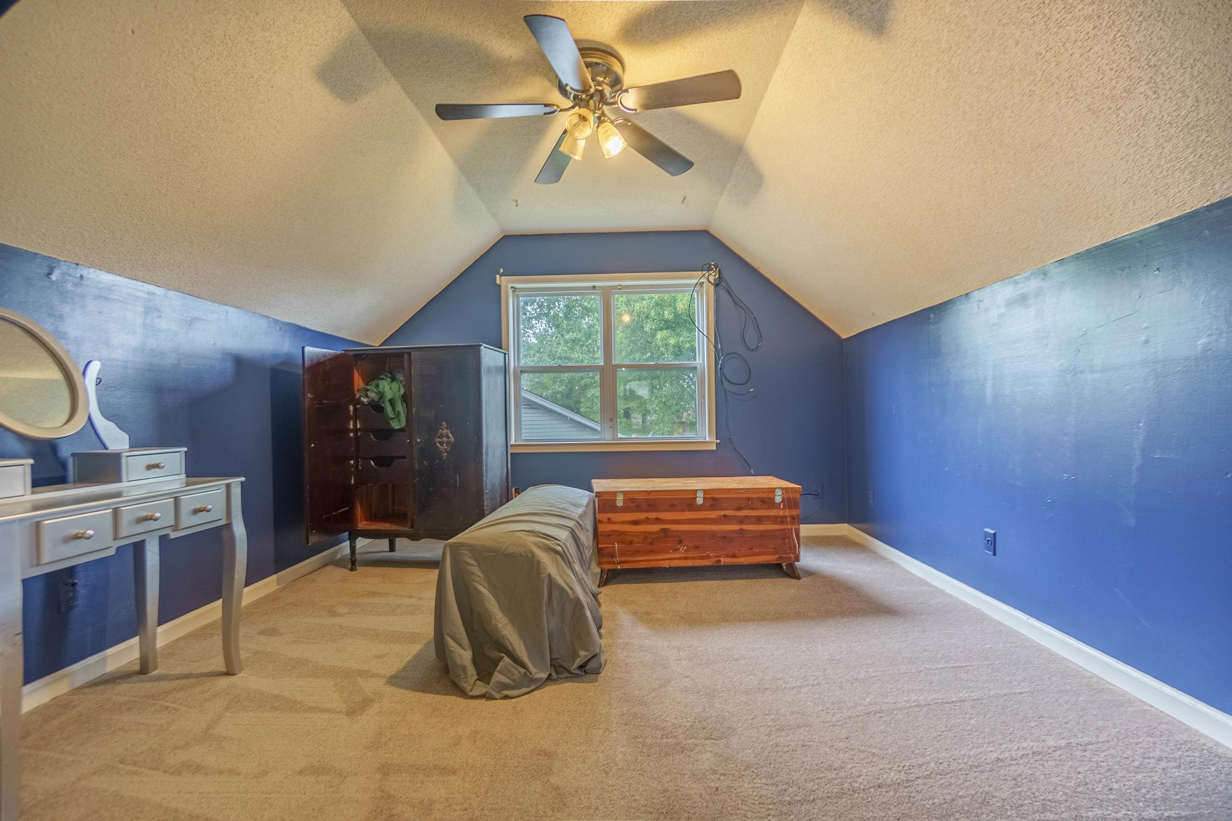 Bedroom featuring ceiling fan, a textured ceiling, light carpet, and vaulted ceiling