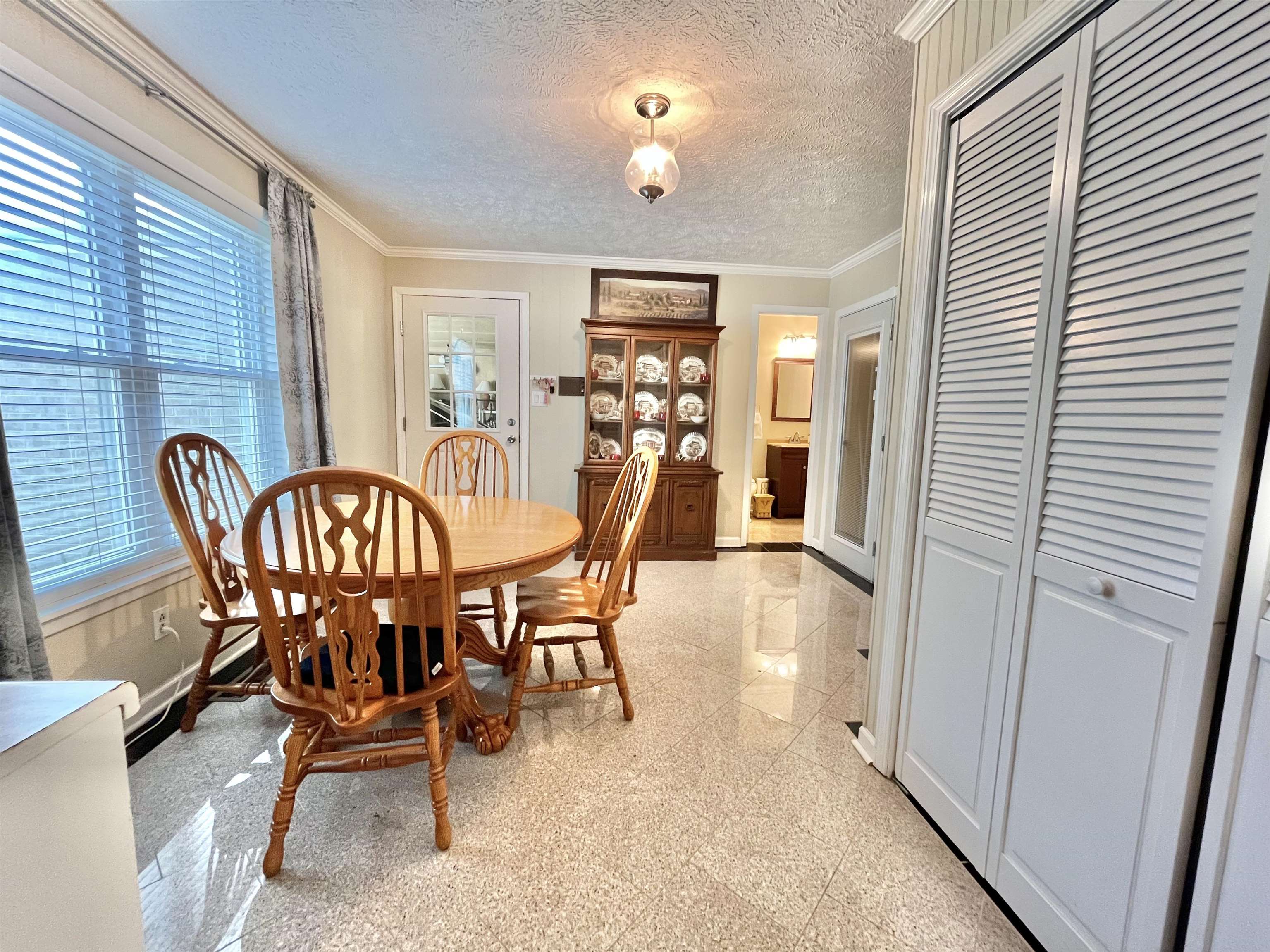 The area leading to the patio houses a washer and dryer in a closet with doors,  and an extra table and chairs to enjoy your coffee at the coffee bar.