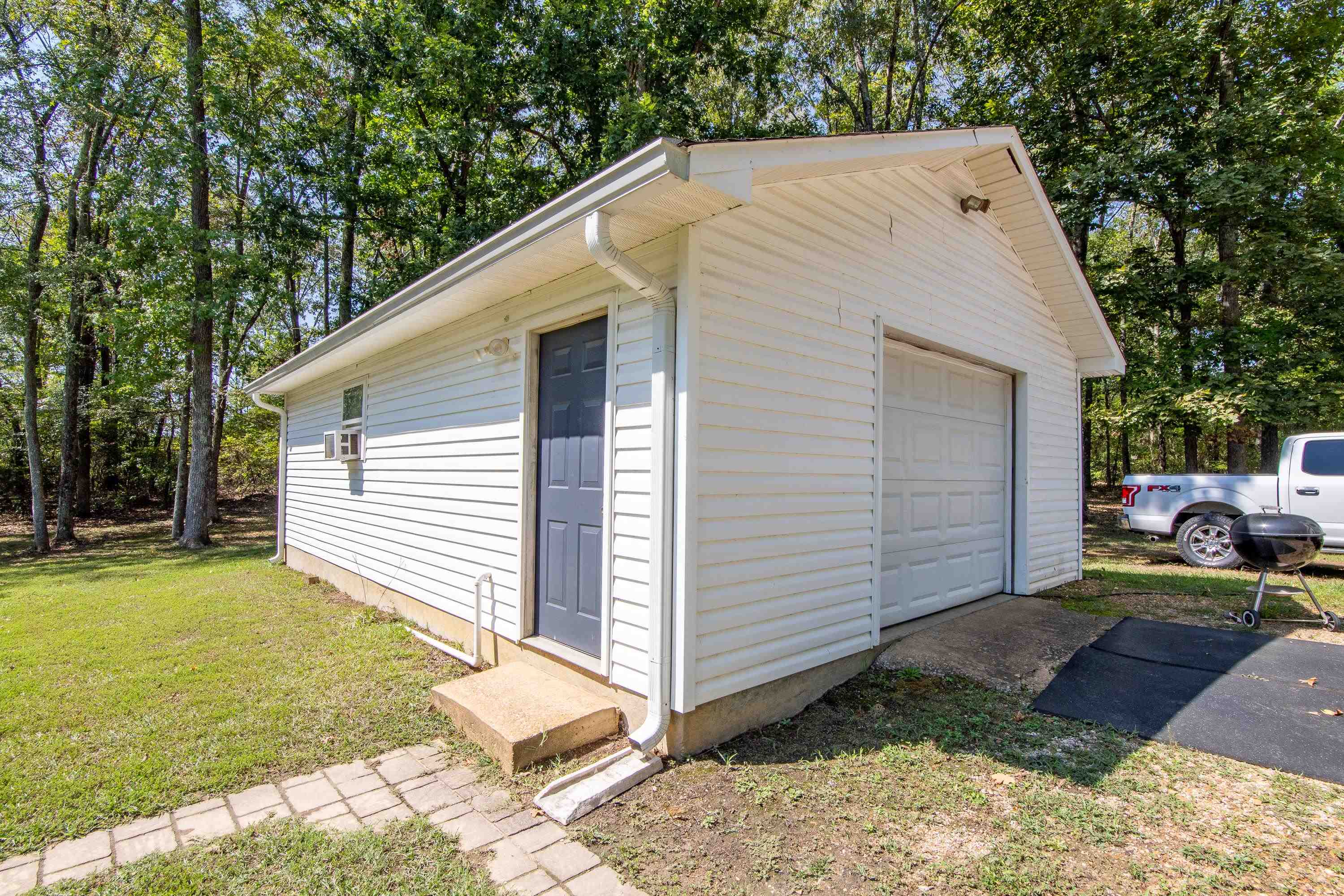 Garage featuring a lawn and cooling unit