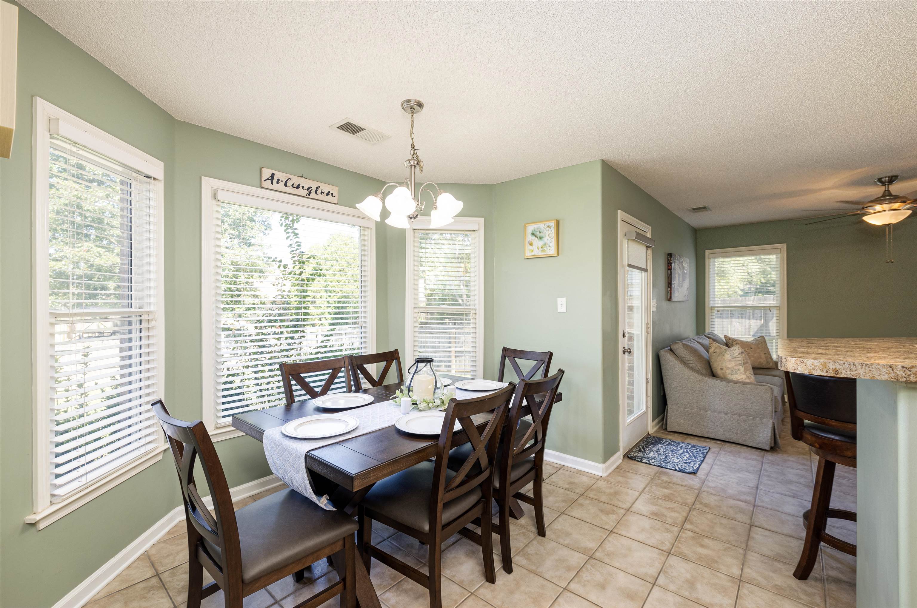 Dining space featuring a textured ceiling, ceiling fan with notable chandelier, and a wealth of natural light