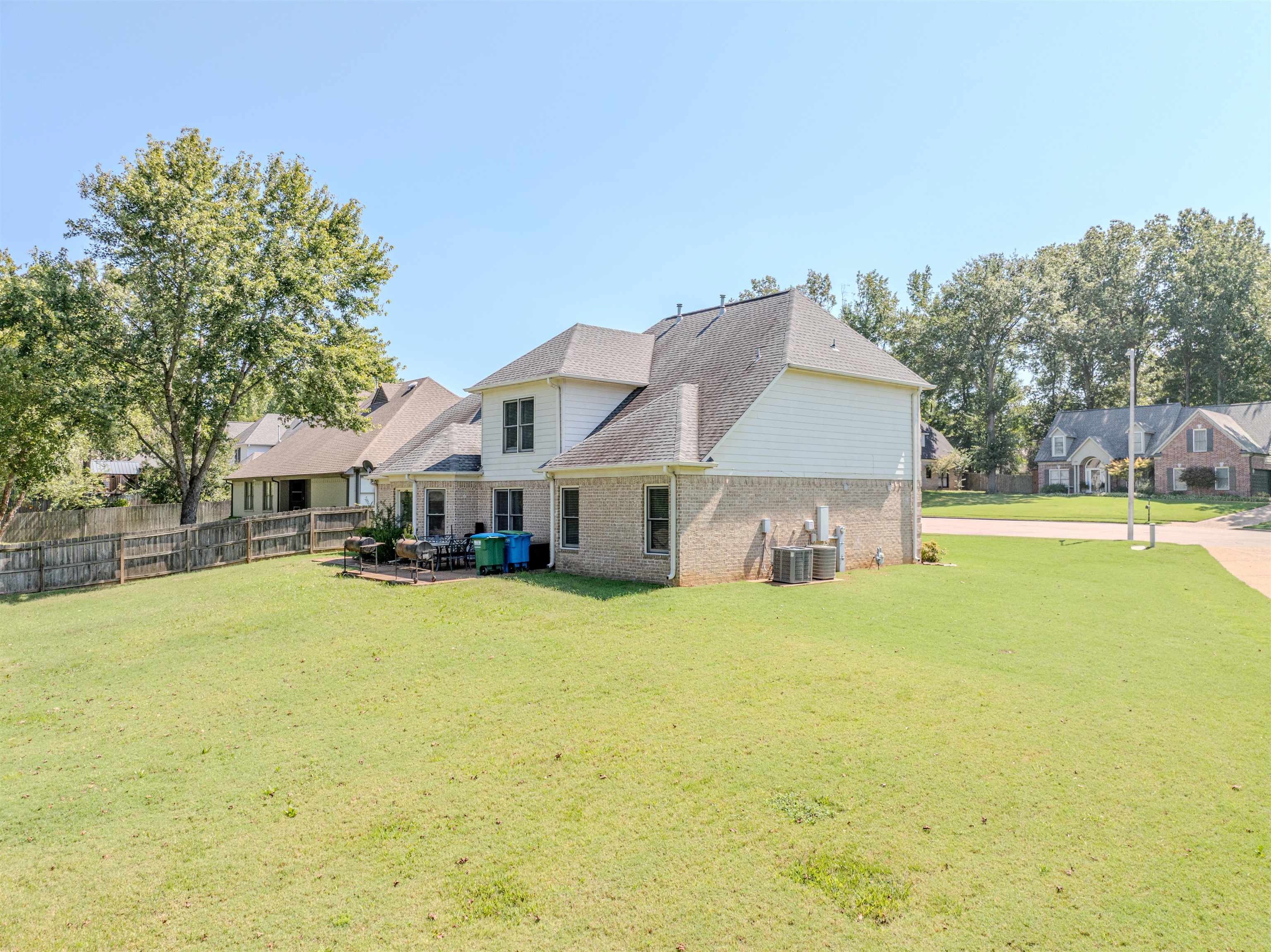 Back of property with central AC and a yard