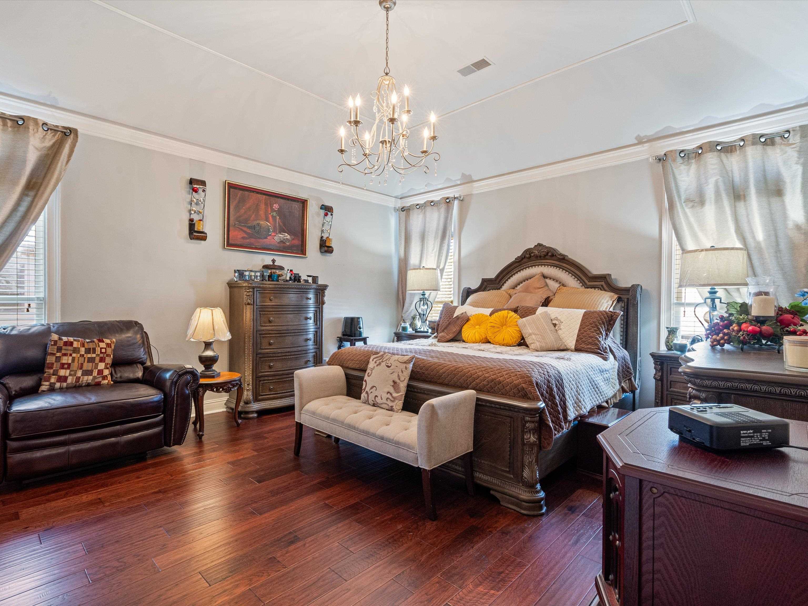 Bedroom featuring dark hardwood / wood-style floors and a chandelier